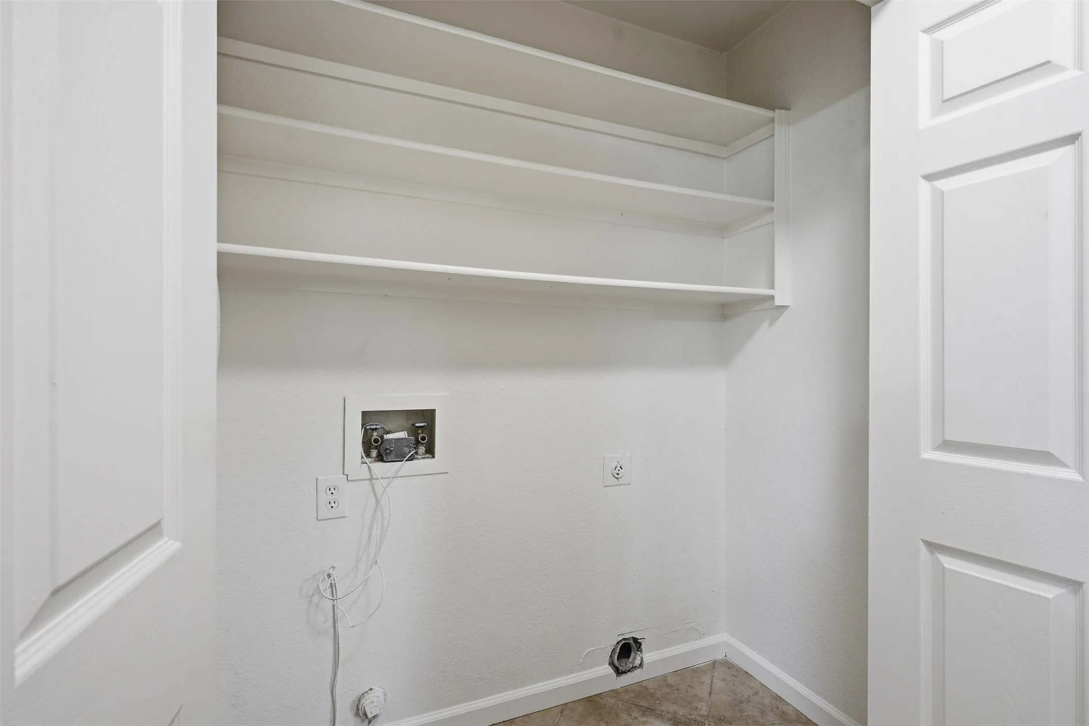 Built-in shelving, tile flooring, and a paneled interior door