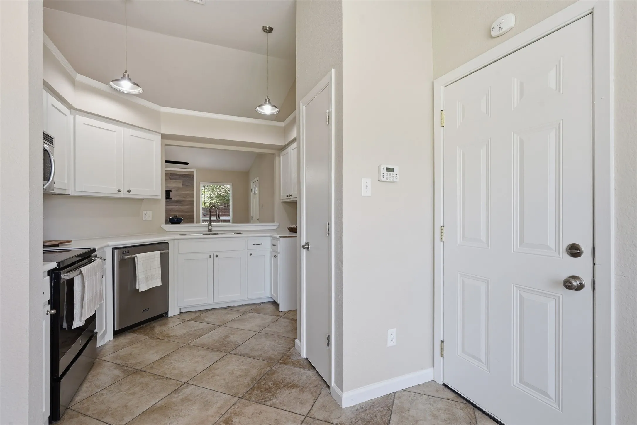 Bay window with horizontal blinds, overhead ceiling fan with light kit, textured walls, and diagonally laid tile flooring
