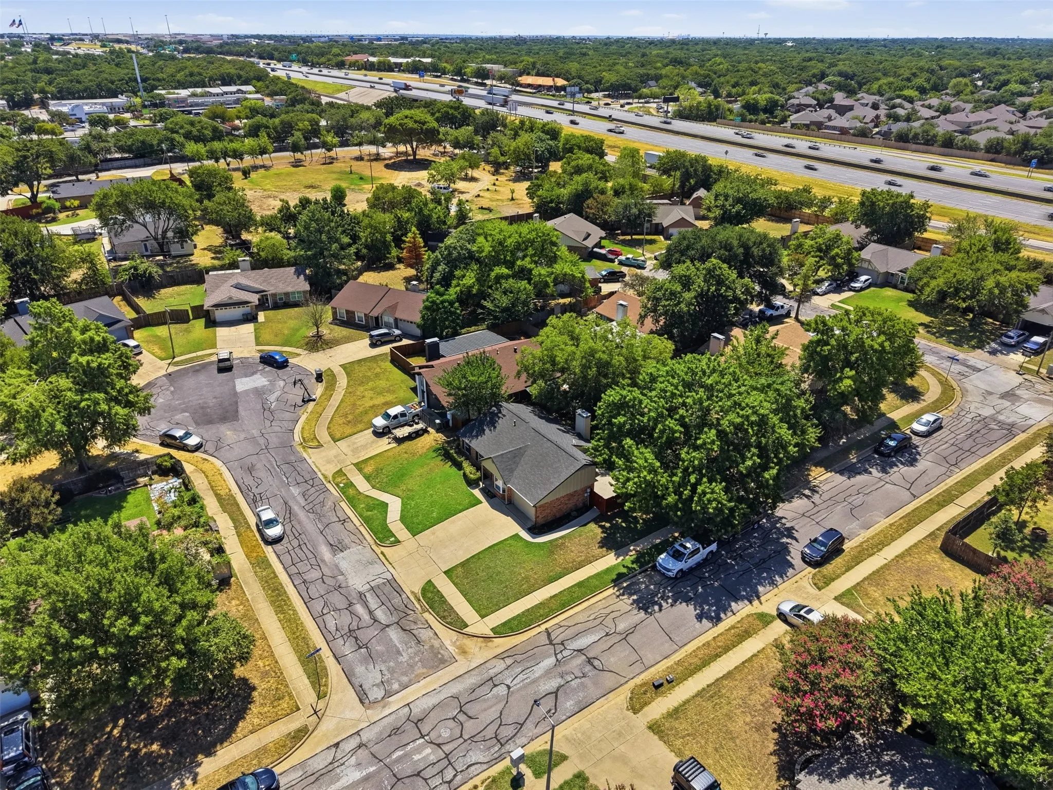 Residential neighborhood with mature trees, established landscaping, and paved street