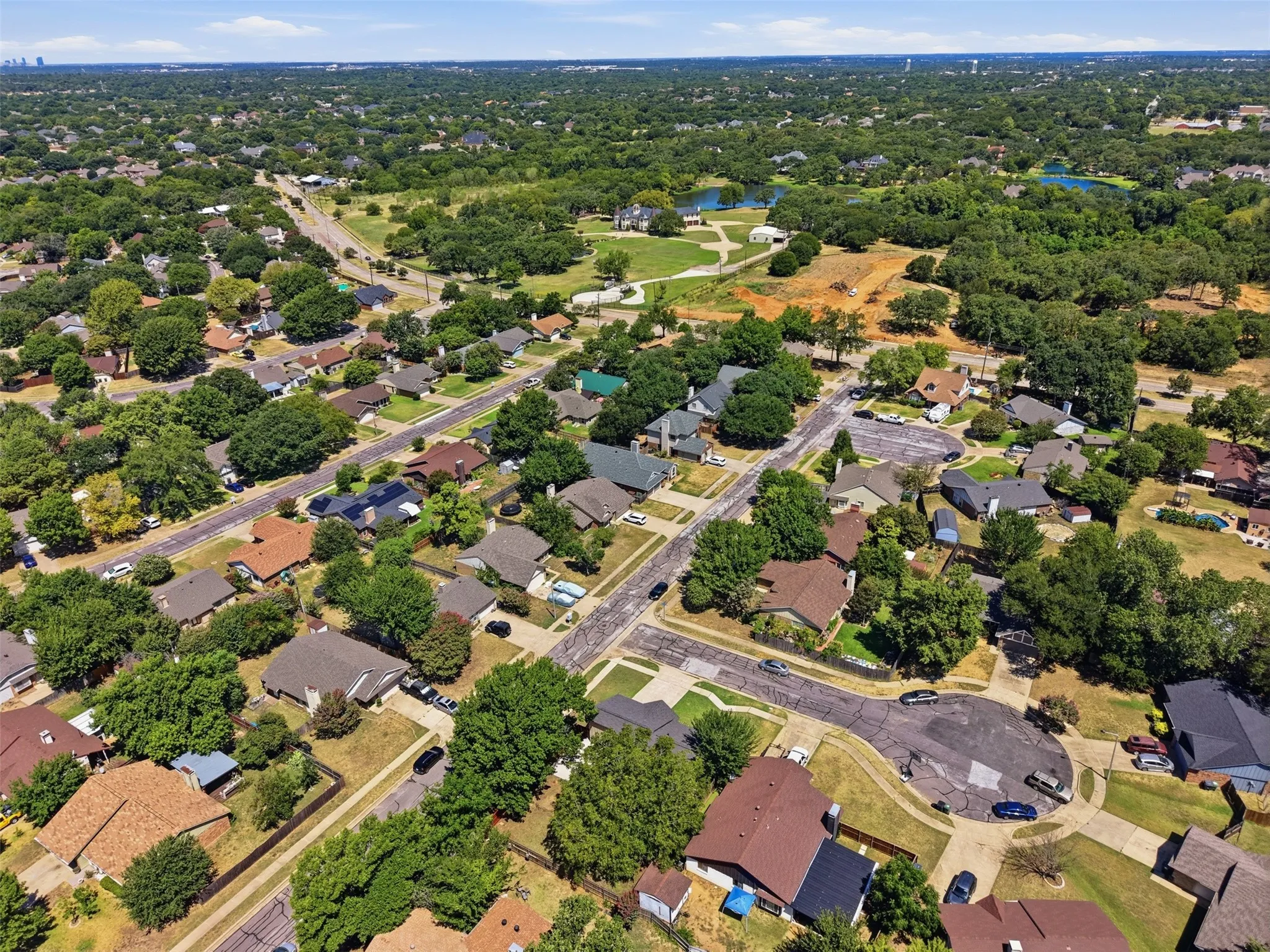 Residential neighborhood with mature trees, established homes, paved streets, and cul-de-sac configurations