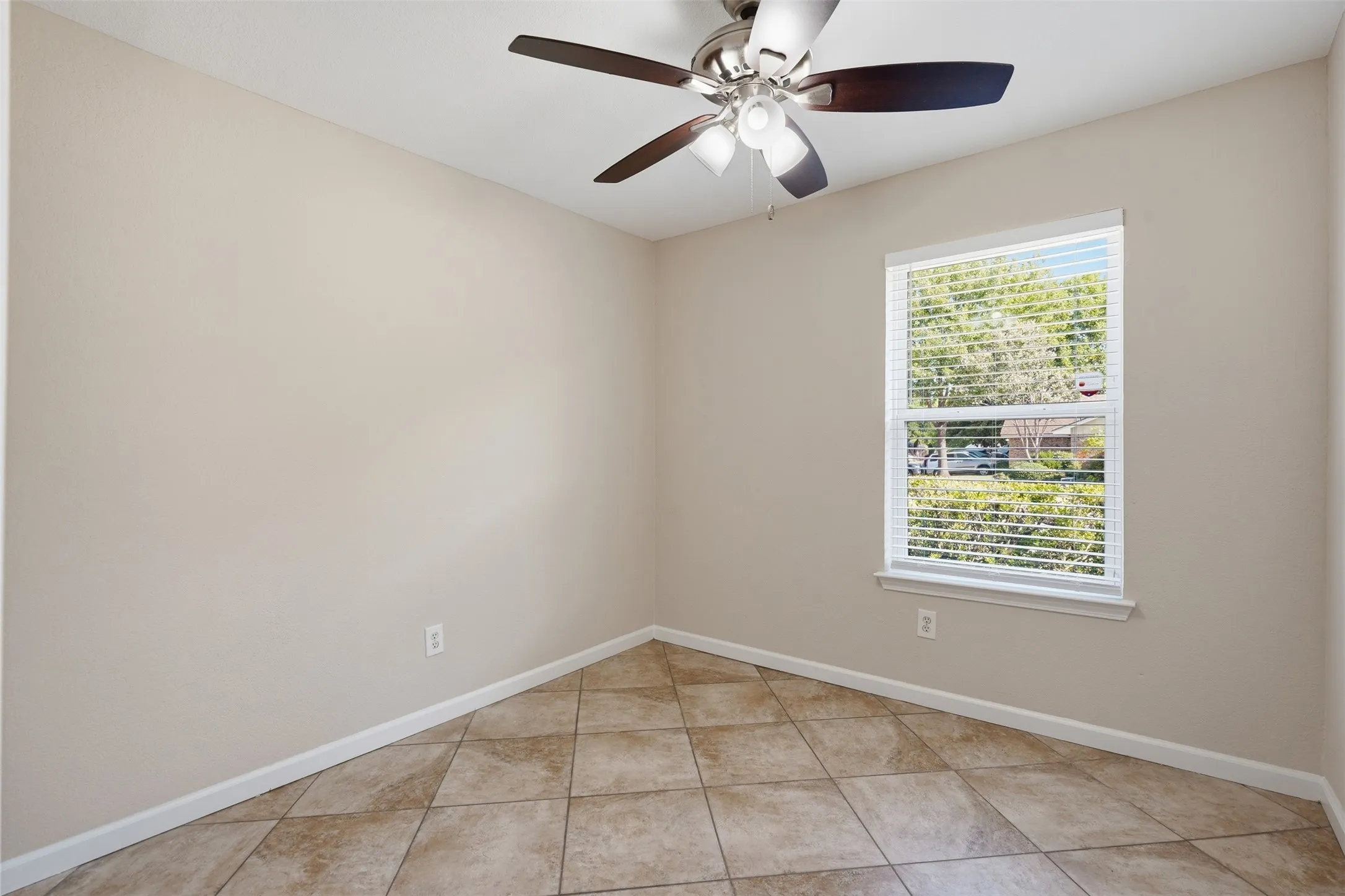 Recessed window with blinds, ceiling fan with light fixture, and diagonal tile flooring