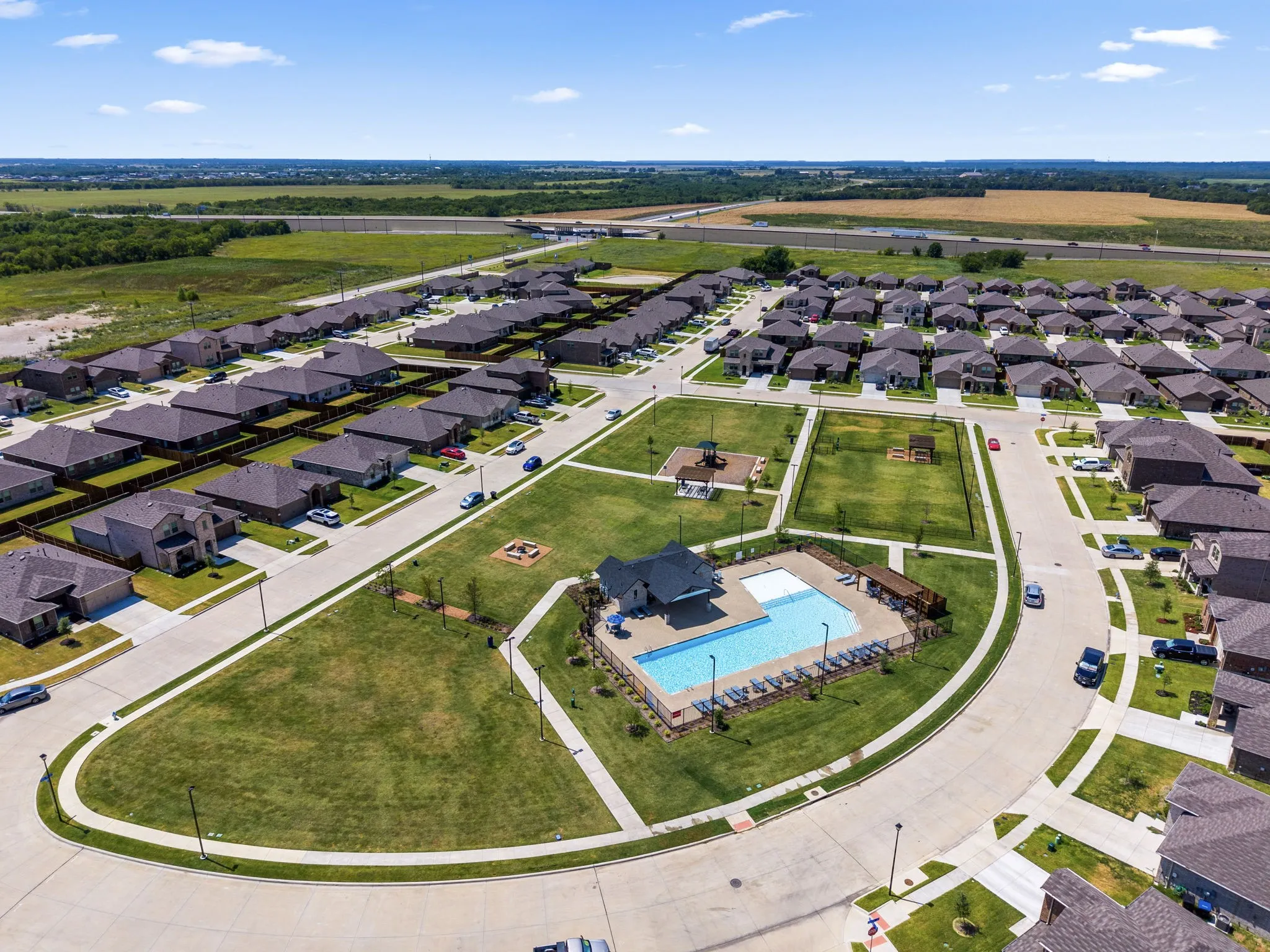 Gated community featuring a resort-style amenity center with sparkling pool and surrounding manicured landscaping