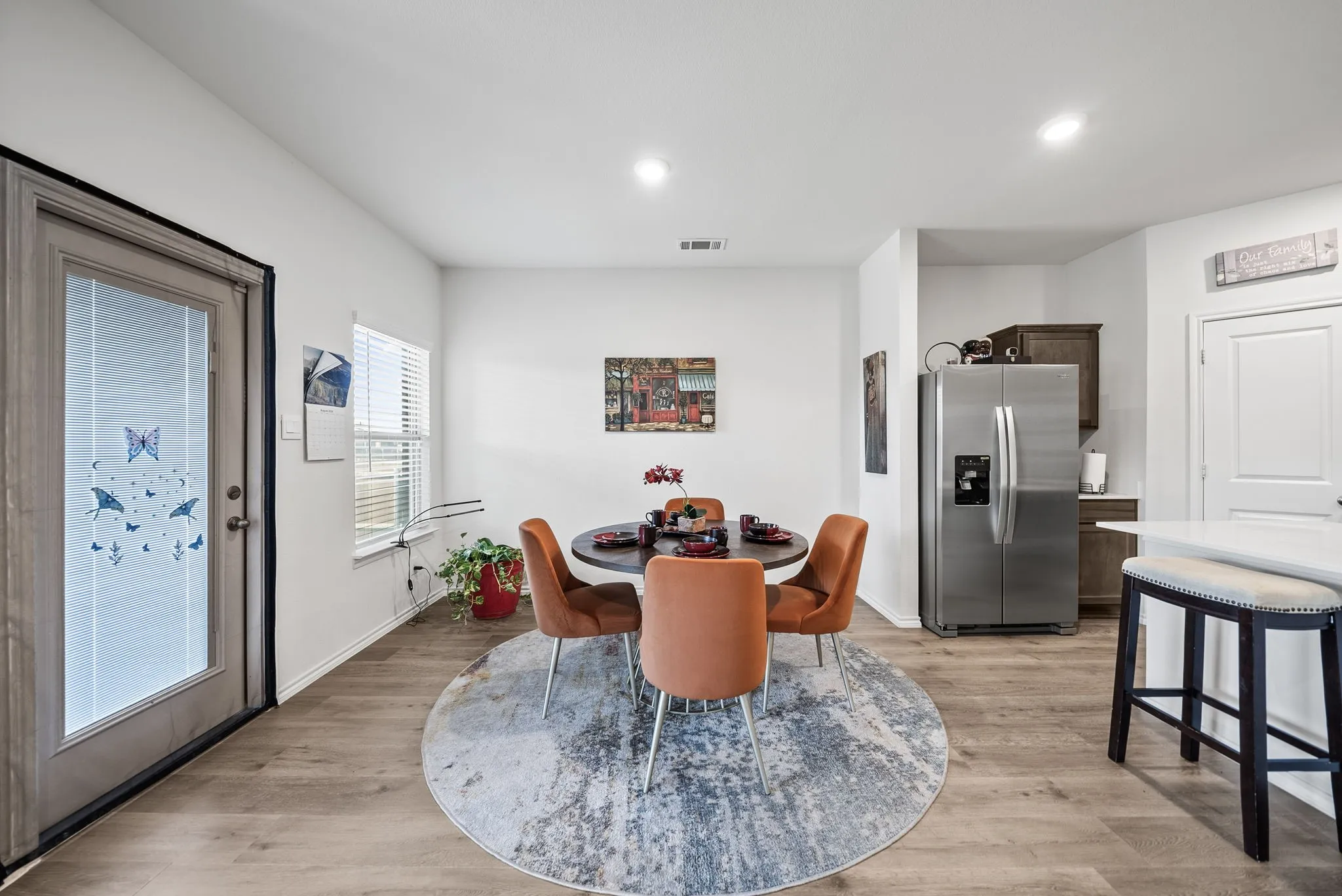 Wood-finish flooring throughout, with a door featuring integrated blinds