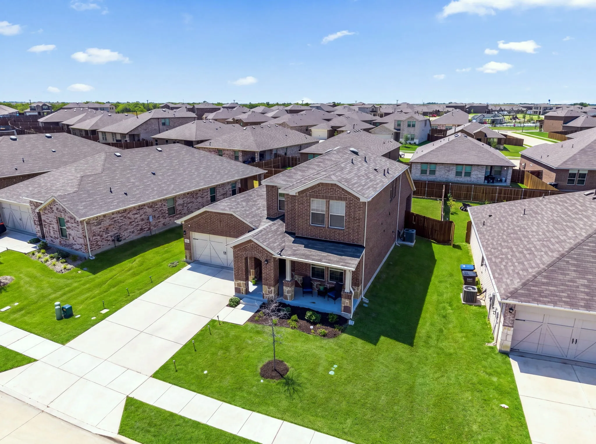 Brick exterior, two-story structure, attached garage, covered front porch, concrete driveway