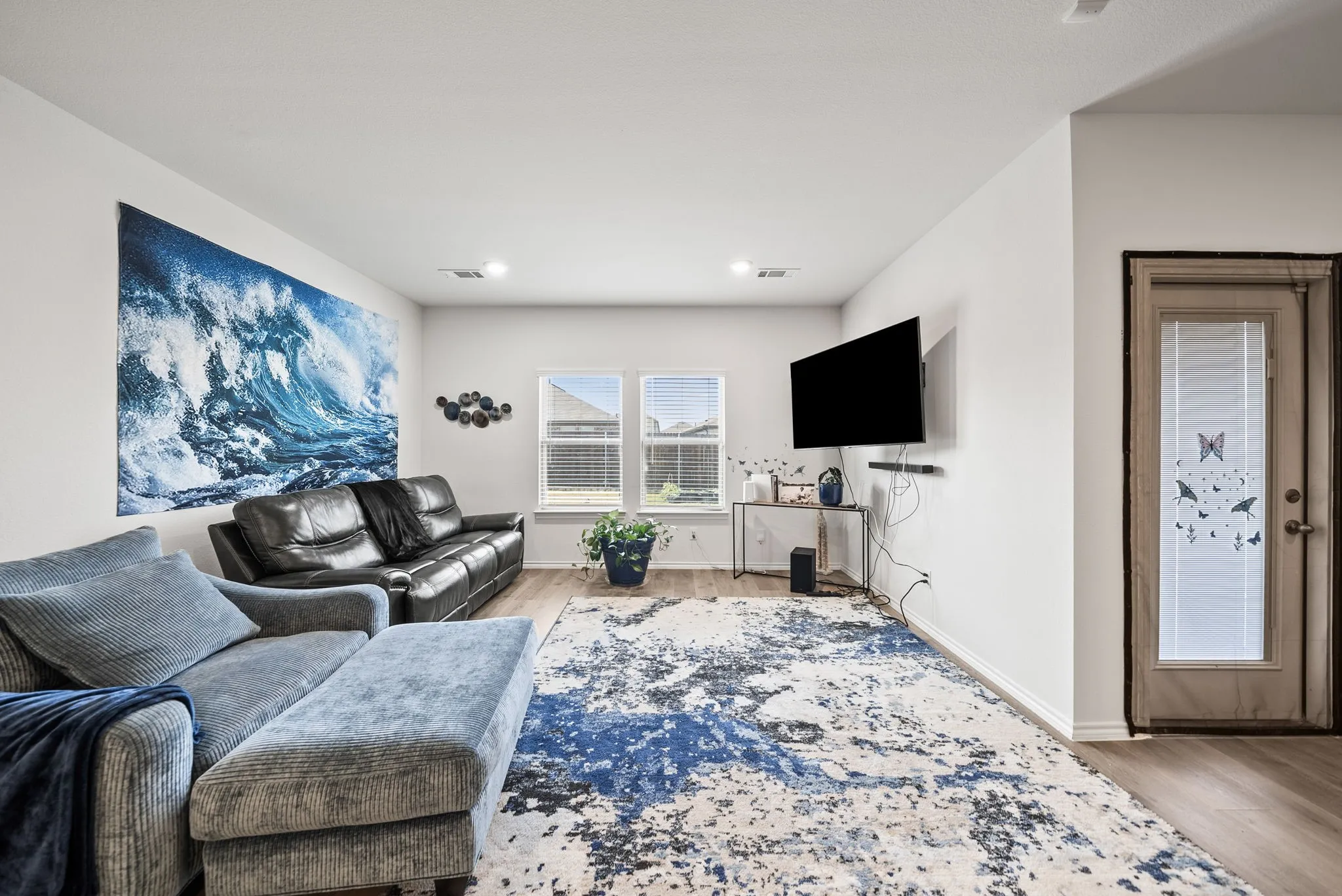 Recessed lighting, wood-finish flooring, and white walls