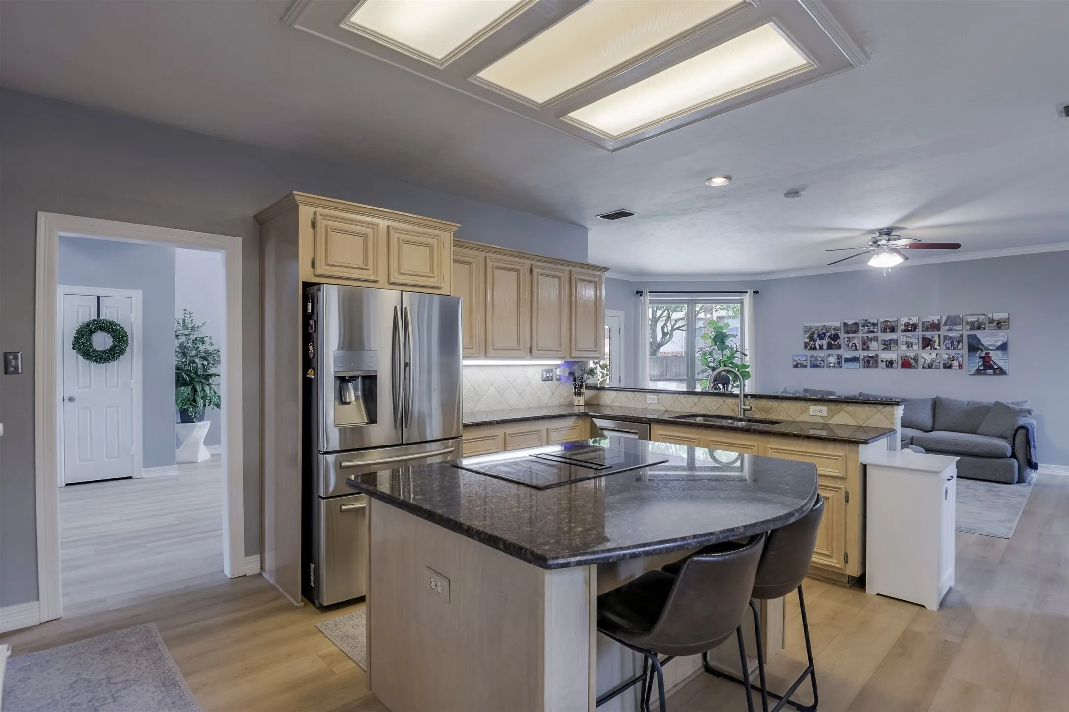 Kitchen featuring wood-finish cabinetry, granite countertops, tile backsplash, and stainless steel appliances