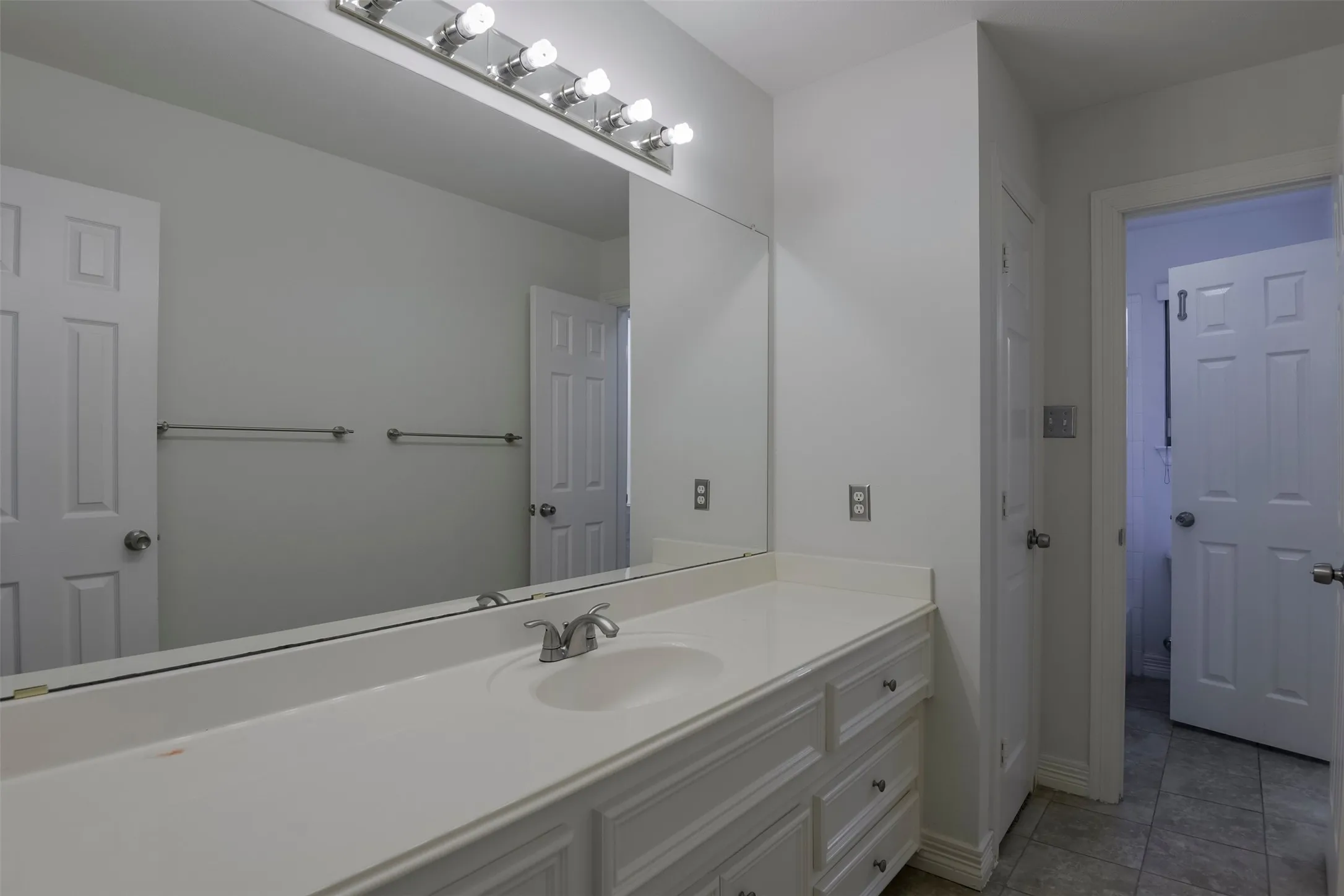 Vanity with an integrated sink, polished chrome faucet, and ample under-sink storage