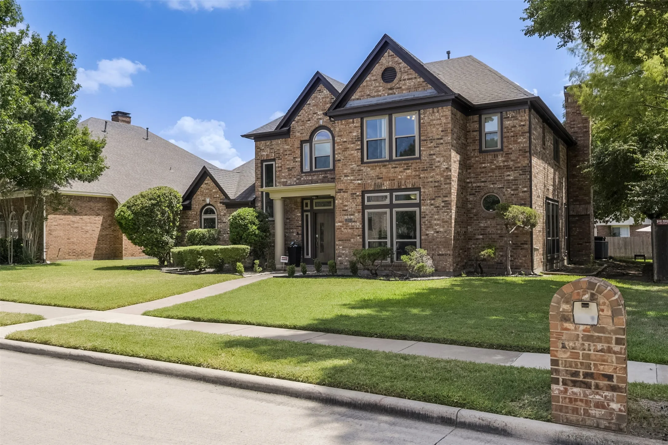 Brick exterior with dark trim windows, arched window accents, and a covered entry