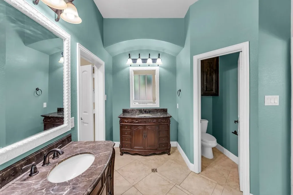 Dual dark wood vanities with integrated sinks and stone countertops