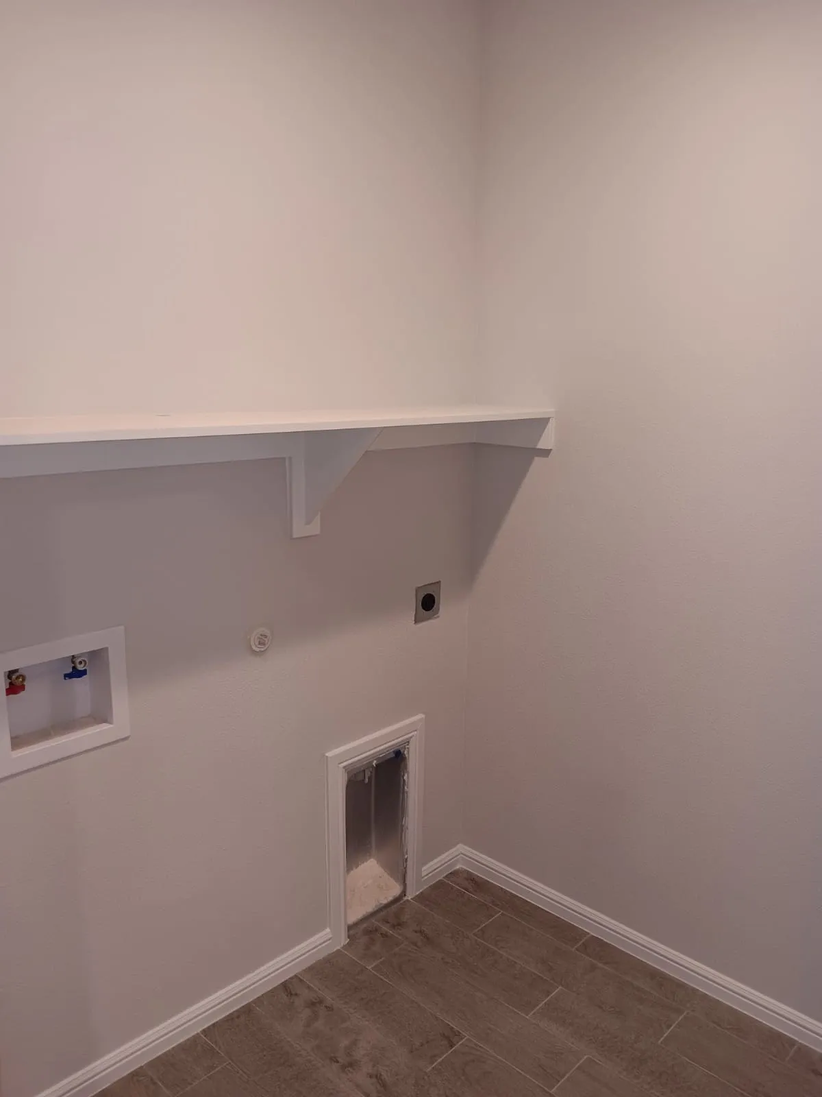 Laundry area featuring a built-in white shelf, tile flooring, and utility hookups