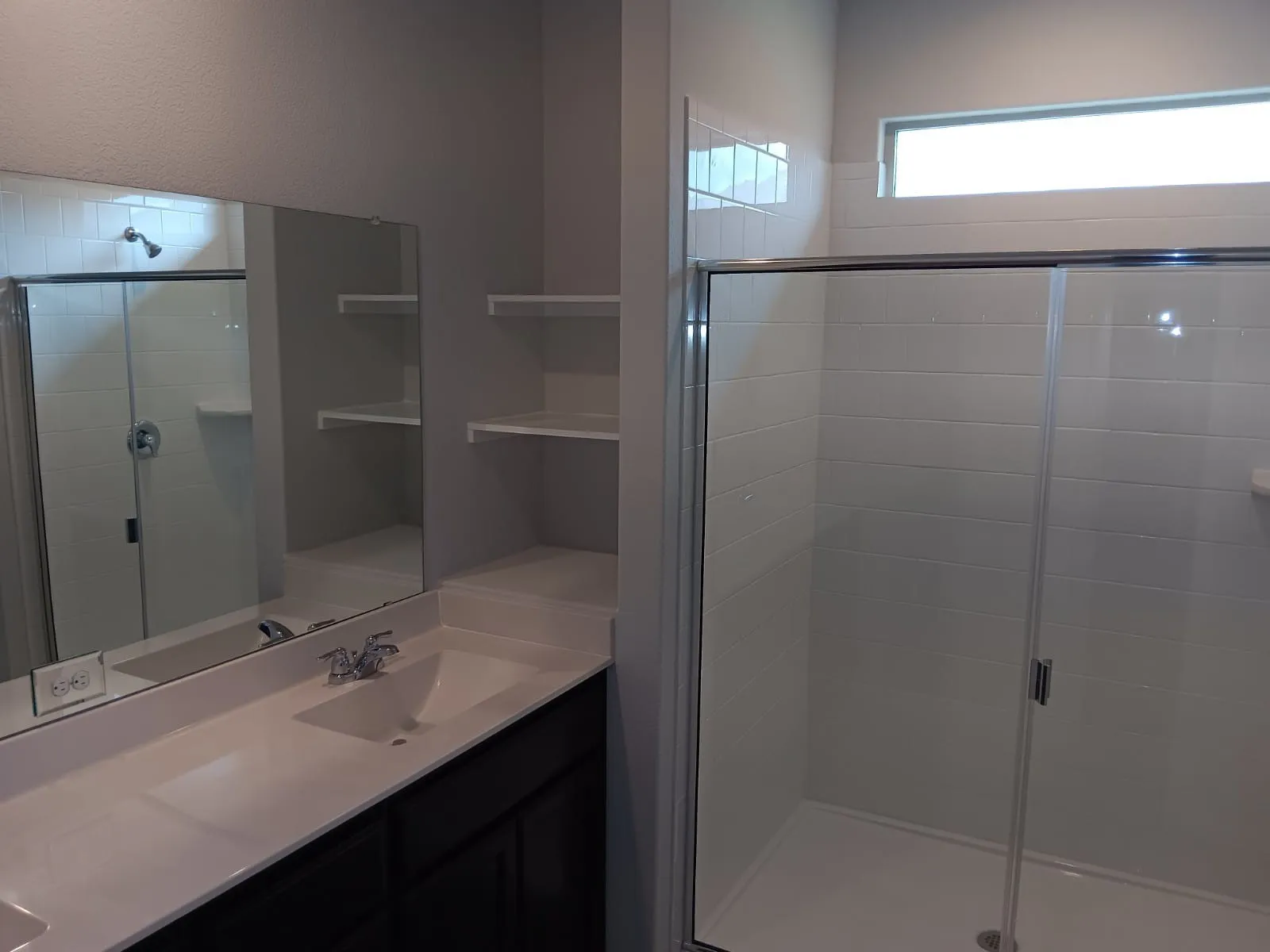 Vanity with integrated sink, chrome faucet, and dark wood-finish cabinetry