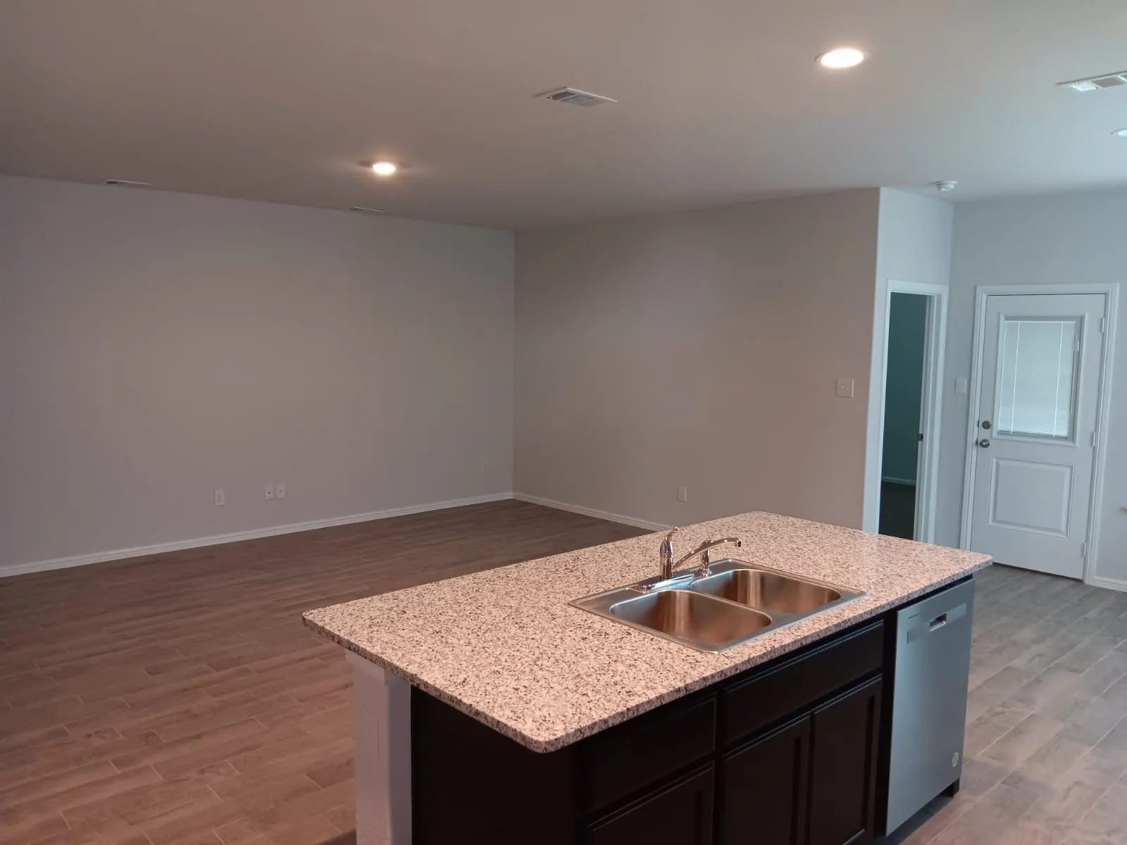 Kitchen island featuring a double basin stainless steel sink and granite countertop
