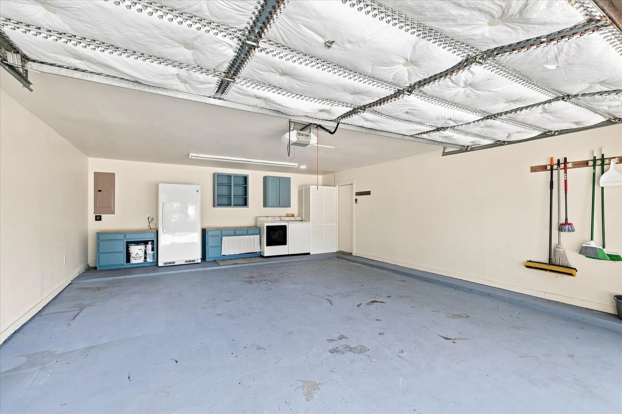 Spacious garage with painted, cabinetry, and laundry area.