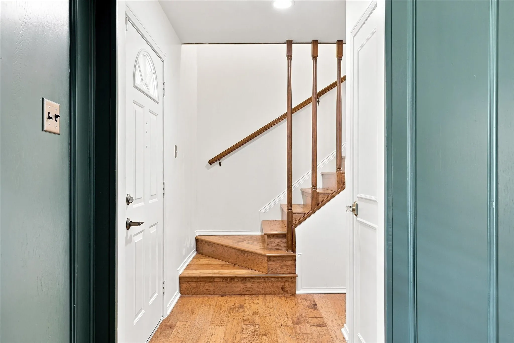 Front entry features a coat closet and wood stairs