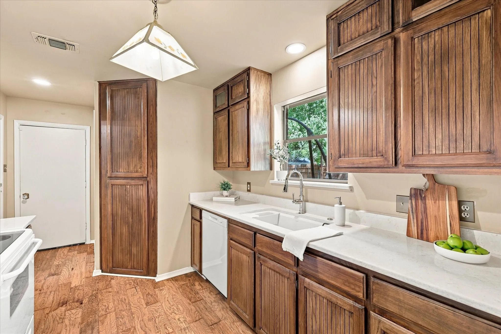The kitchen features ceiling-height cabinets, marble countertops, a Kohler sink, vintage tile backsplash behind the range and recently replaced dishwasher and garbage disposal.
