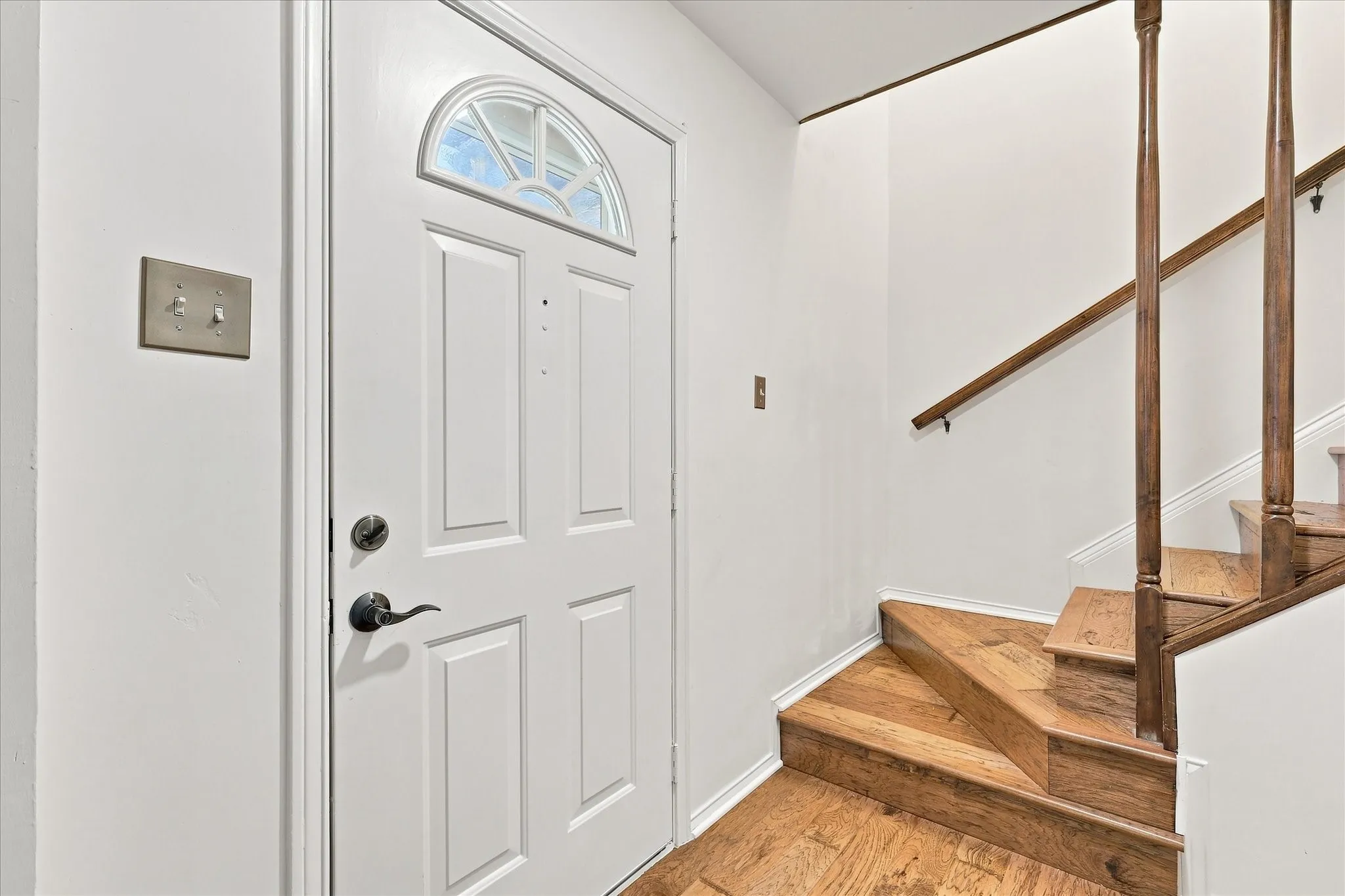Front entry features a coat closet and wood stairs