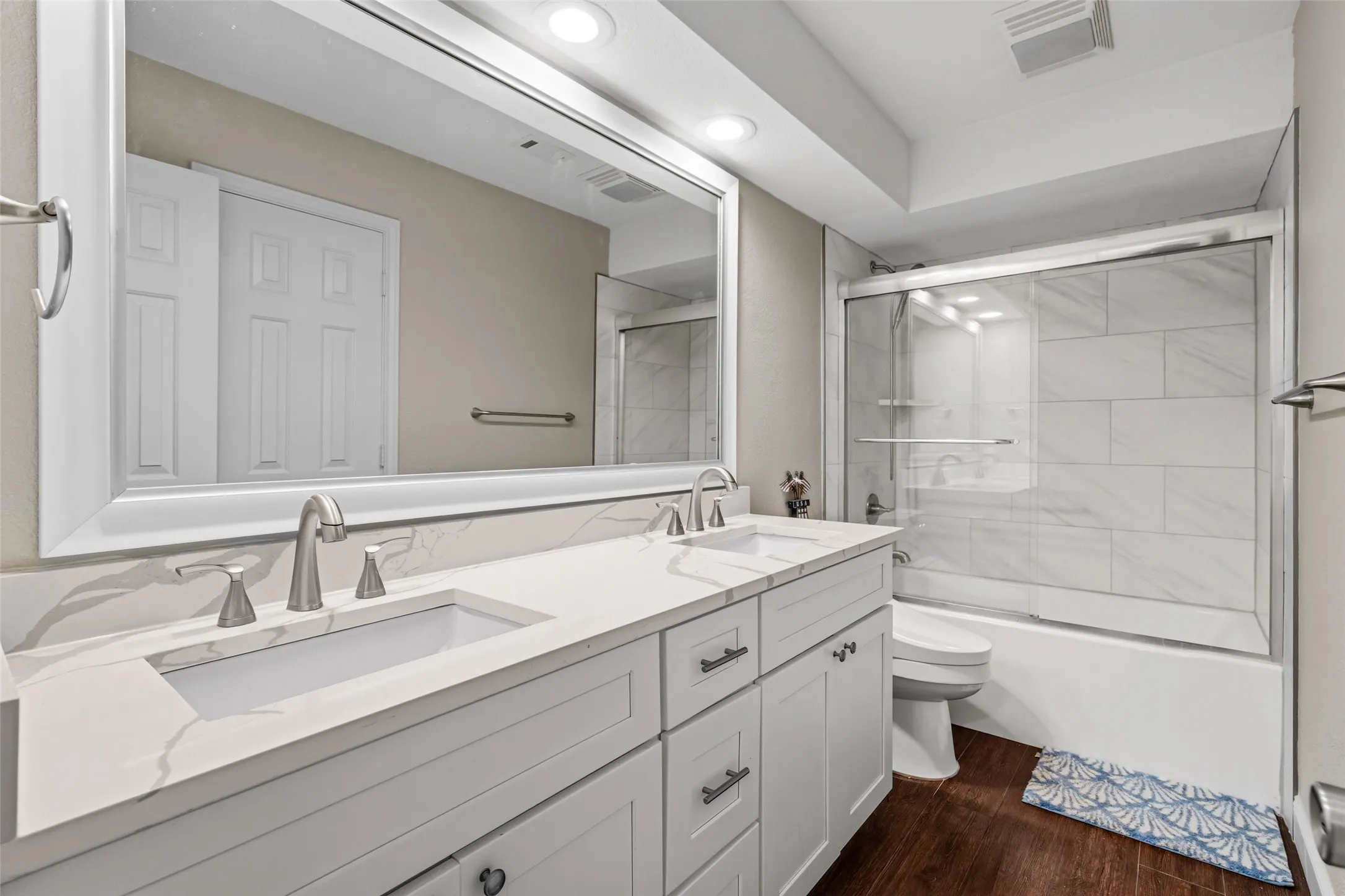 Double vanity with undermount sinks, white cabinetry, and brushed nickel fixtures
