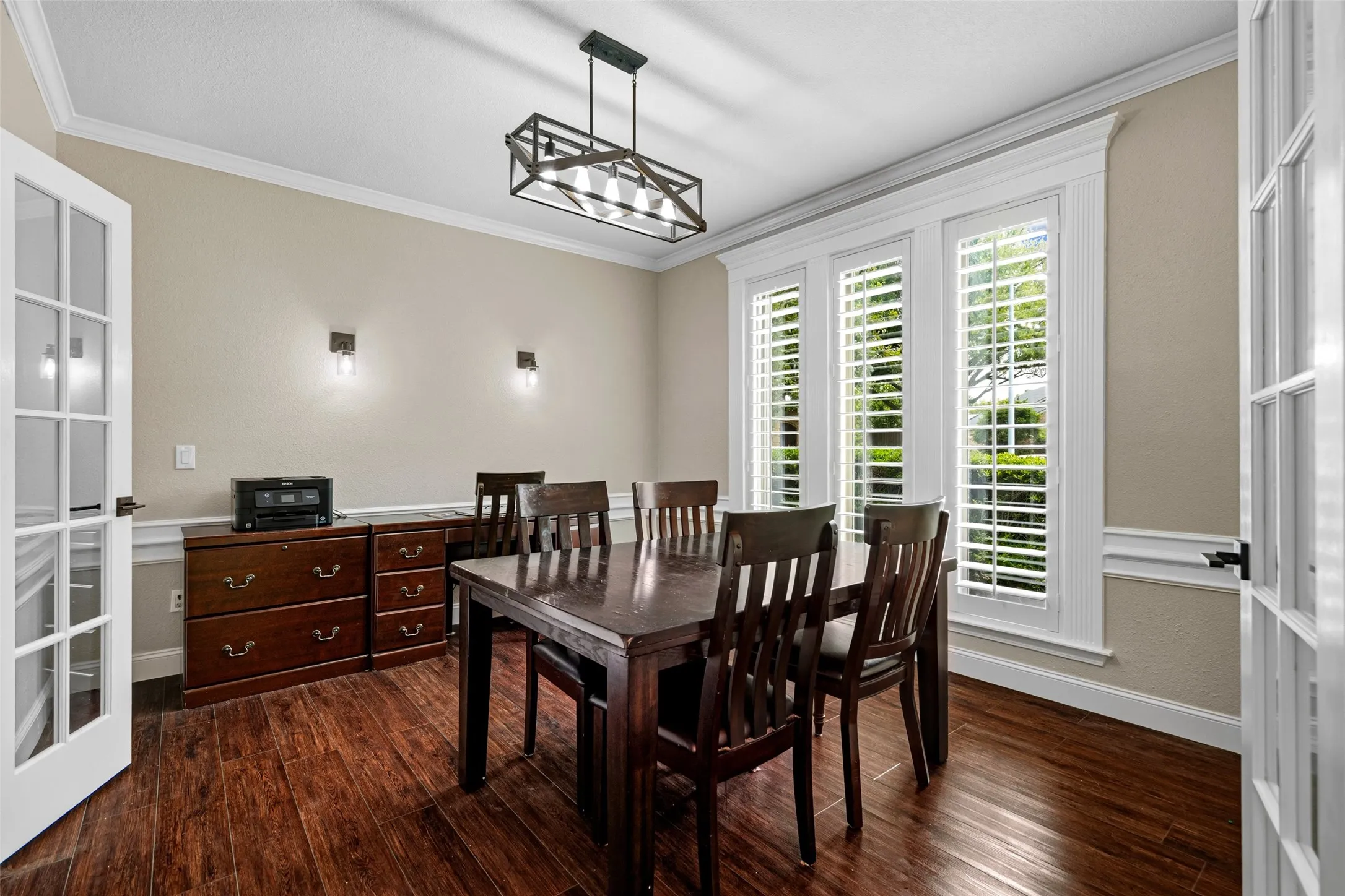 Dark wood-finish flooring with white trim and crown molding