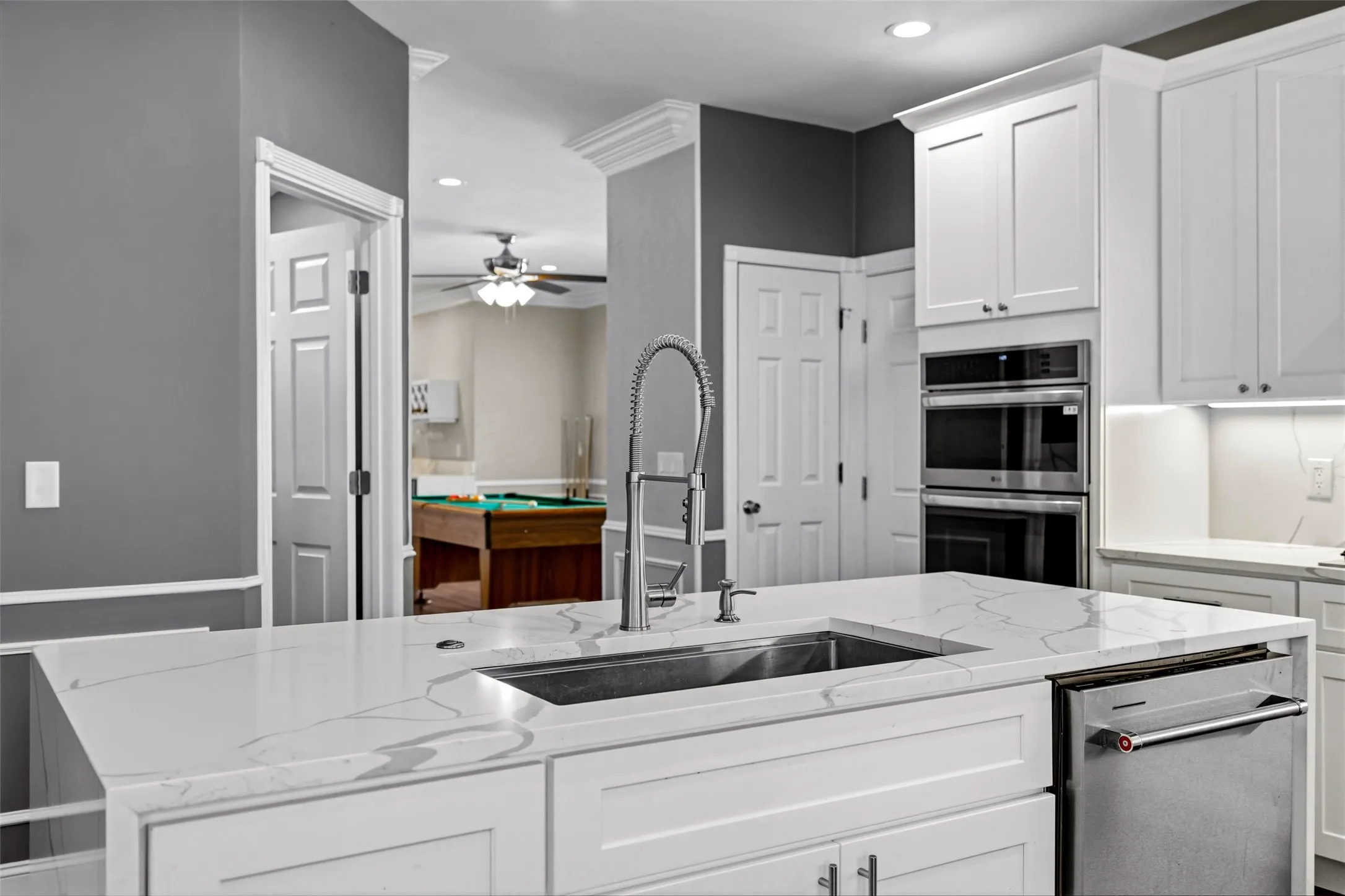 Kitchen island with an undermount sink, gooseneck faucet, and integrated dishwasher