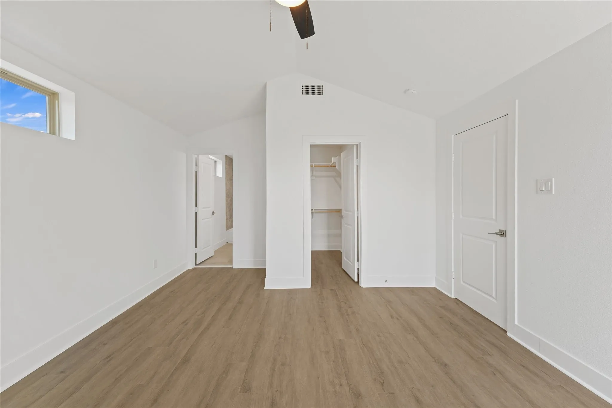 Vaulted ceilings, wood-finish flooring, and a ceiling fan