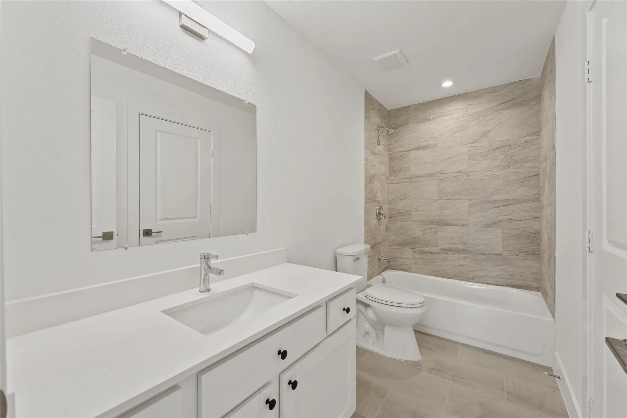 White vanity with undermount sink, chrome faucet, and black hardware