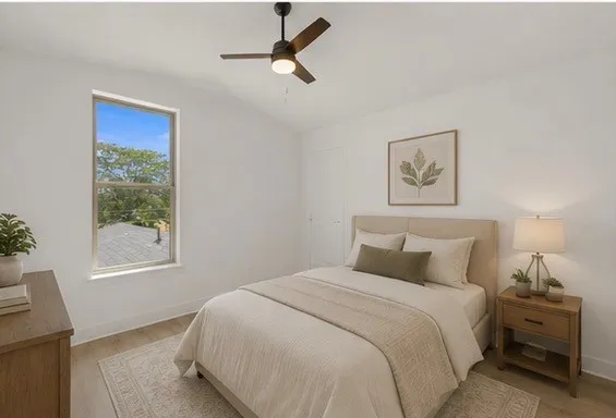 Vaulted ceiling, ceiling fan with integrated lighting, wood-finish flooring, white walls, and a single window