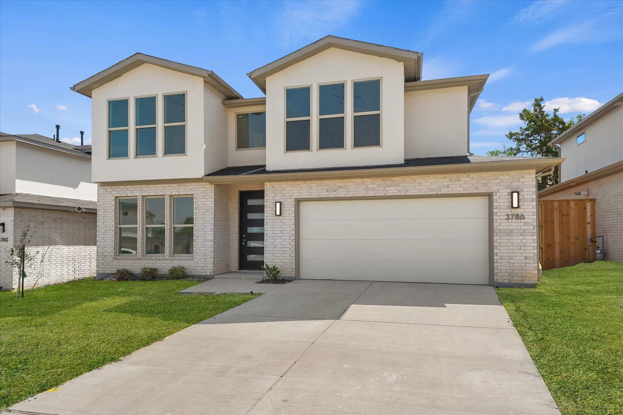 Contemporary two-story exterior with light-colored brick and stucco finishes