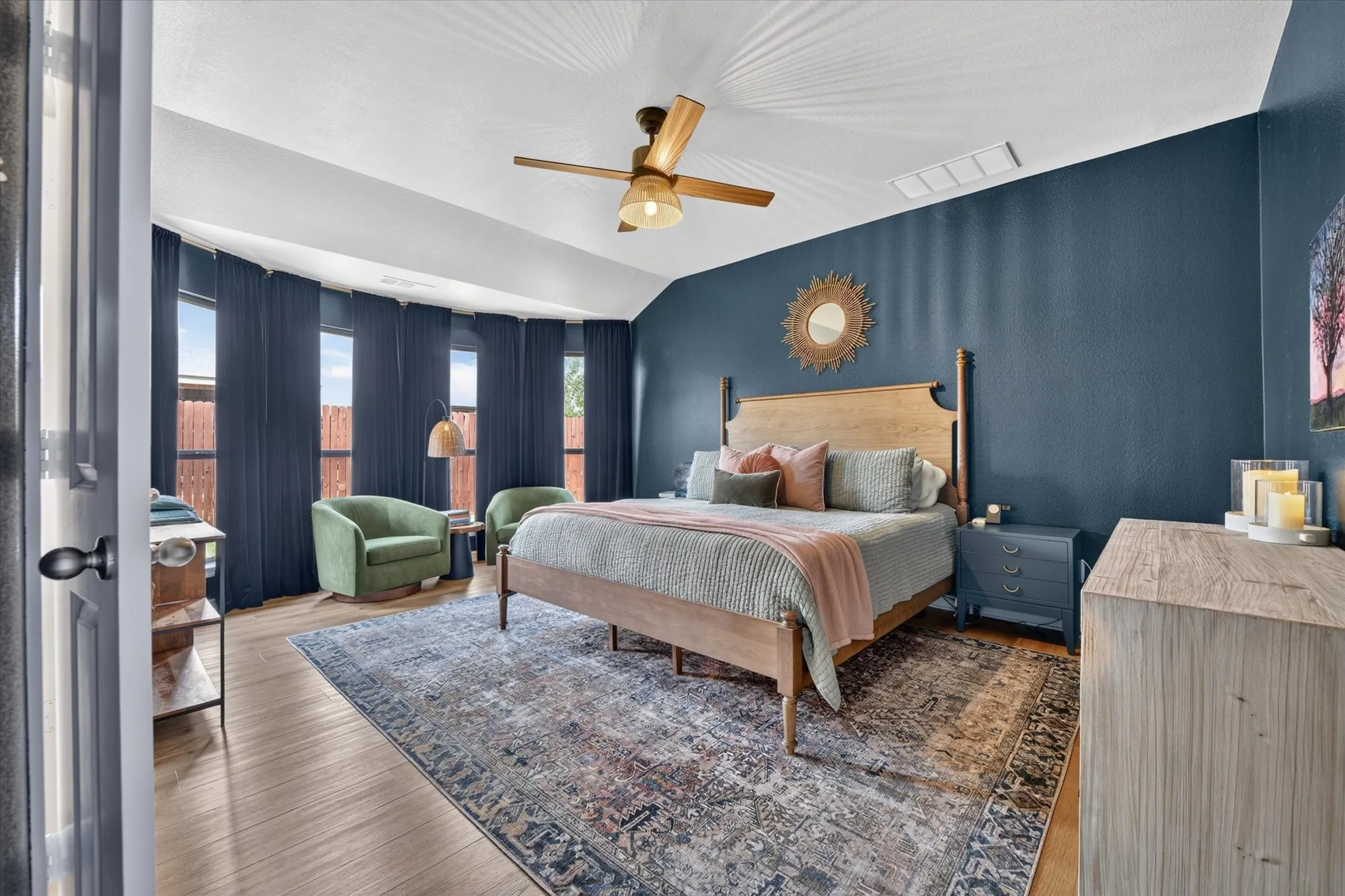 Wood-finish flooring with a ceiling fan, a series of five windows, and a built-in closet door