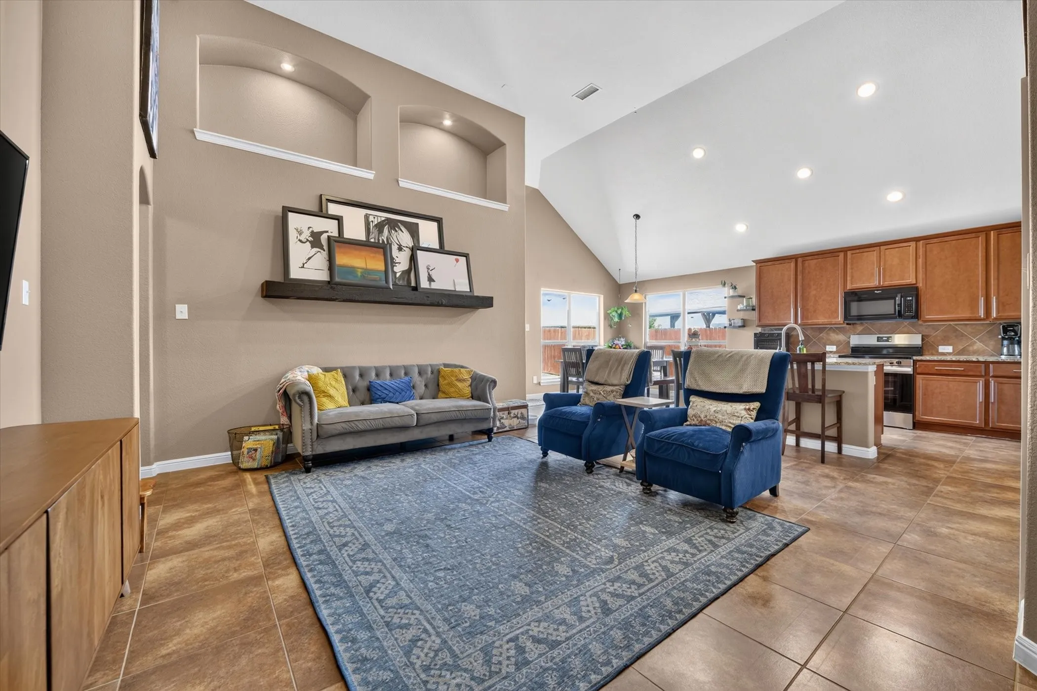 Vaulted ceilings with recessed lighting, tile flooring, and integrated wall niches