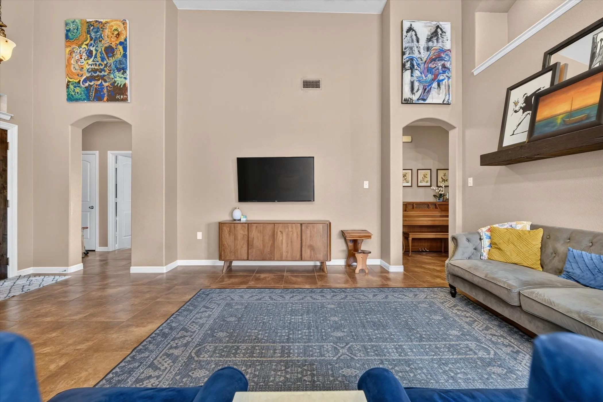 Vaulted ceiling with archway entries and wood-finish flooring