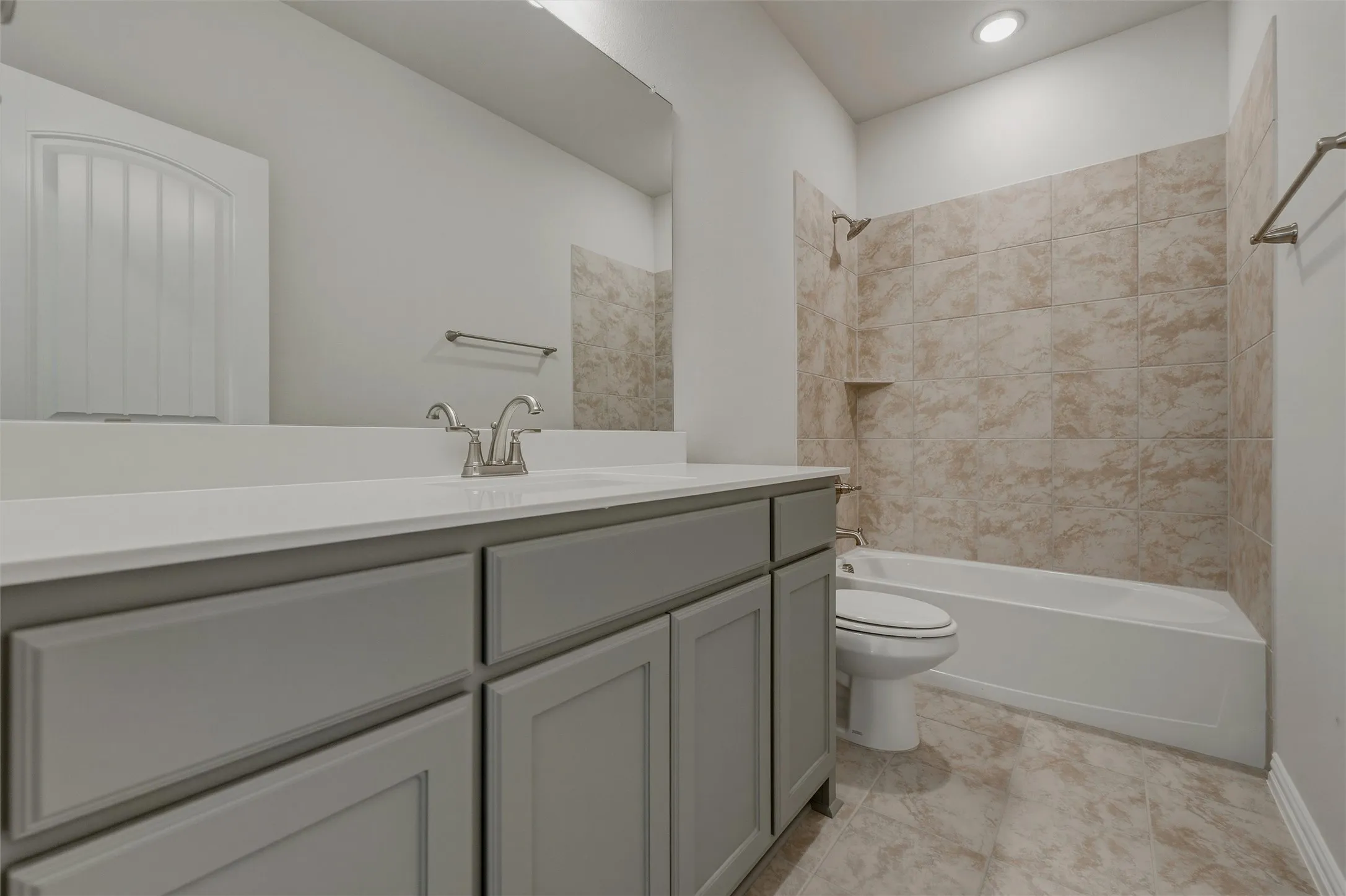 Gray vanity with brushed nickel hardware, white countertop, integrated sink, tiled shower/tub combination, and recessed lighting
