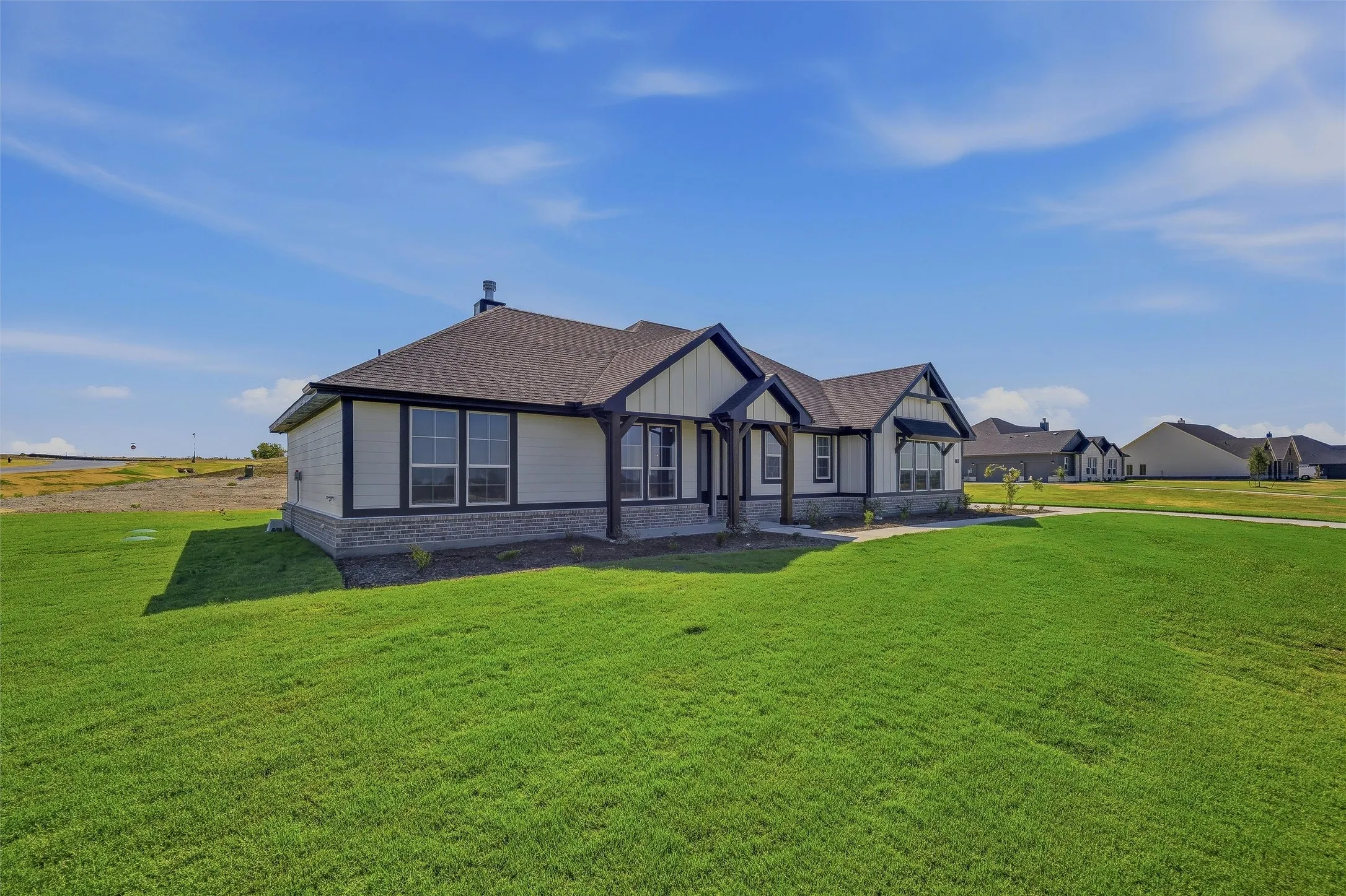 Modern prairie-style architecture featuring a covered entry, multiple gables, and a stone accent facade