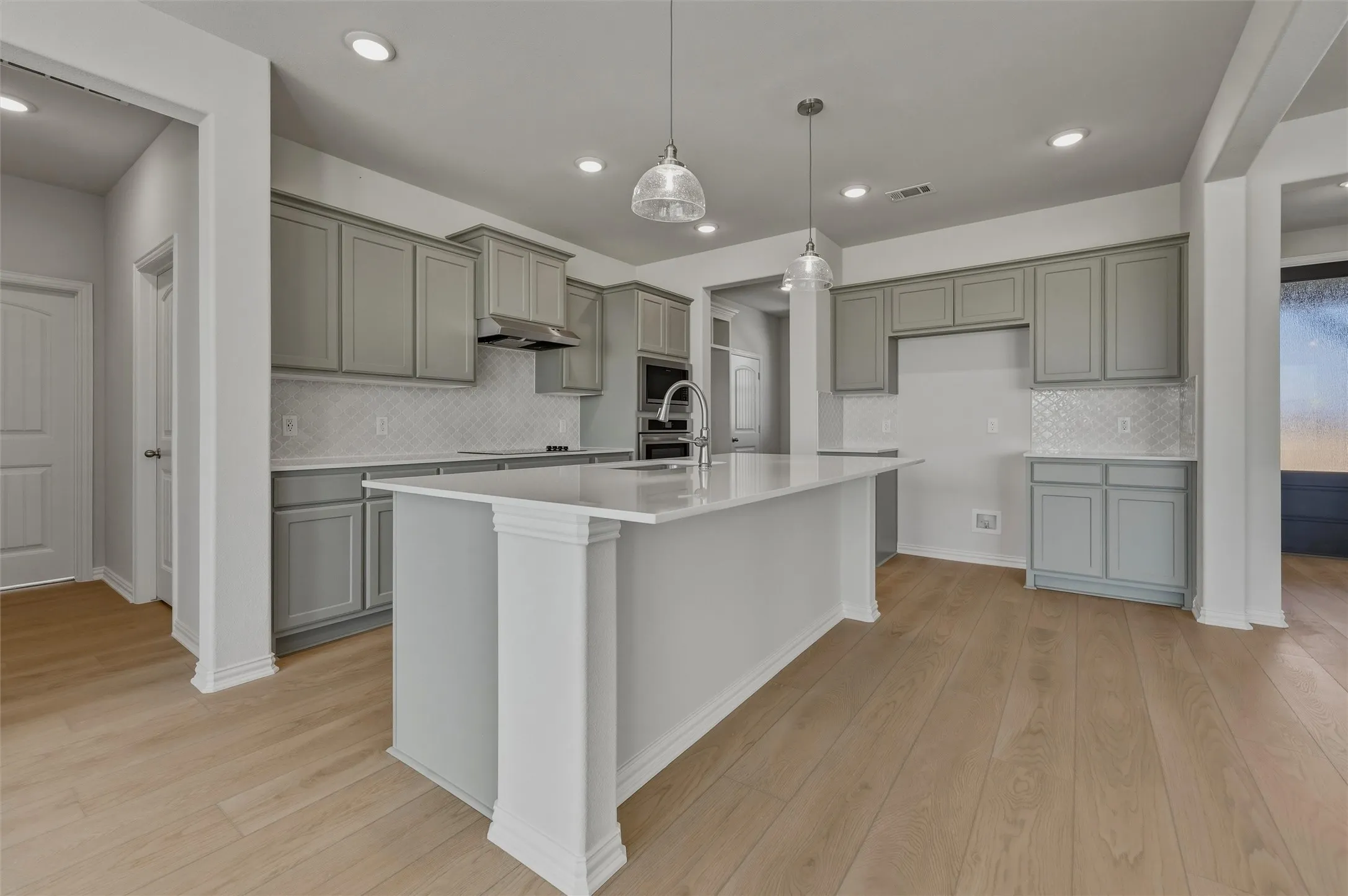 Kitchen featuring light wood-finish flooring, recessed lighting, and a kitchen island with pendant lighting
