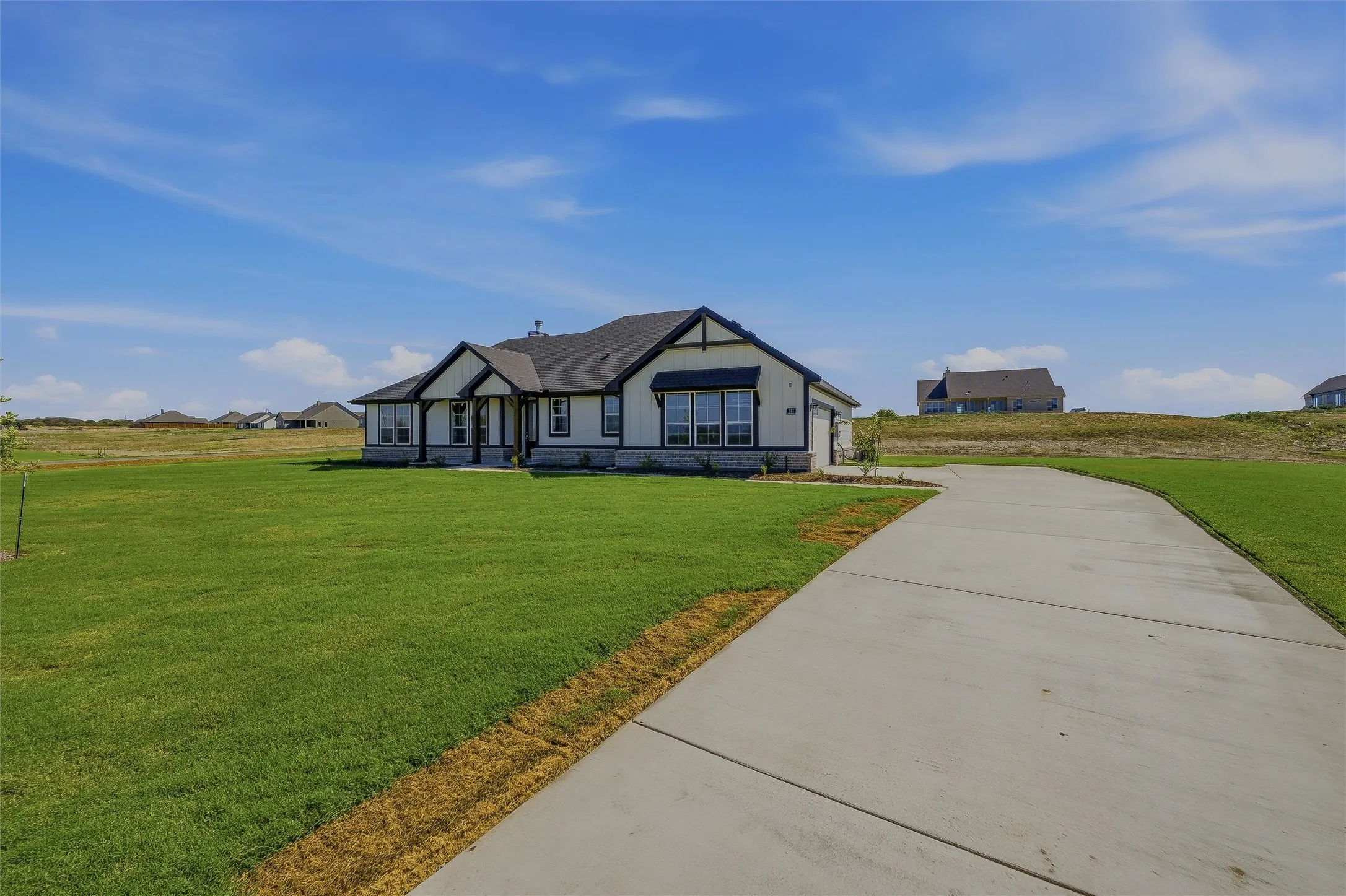 Single-story residence featuring a dark shingle roof and a light-colored exterior with dark trim