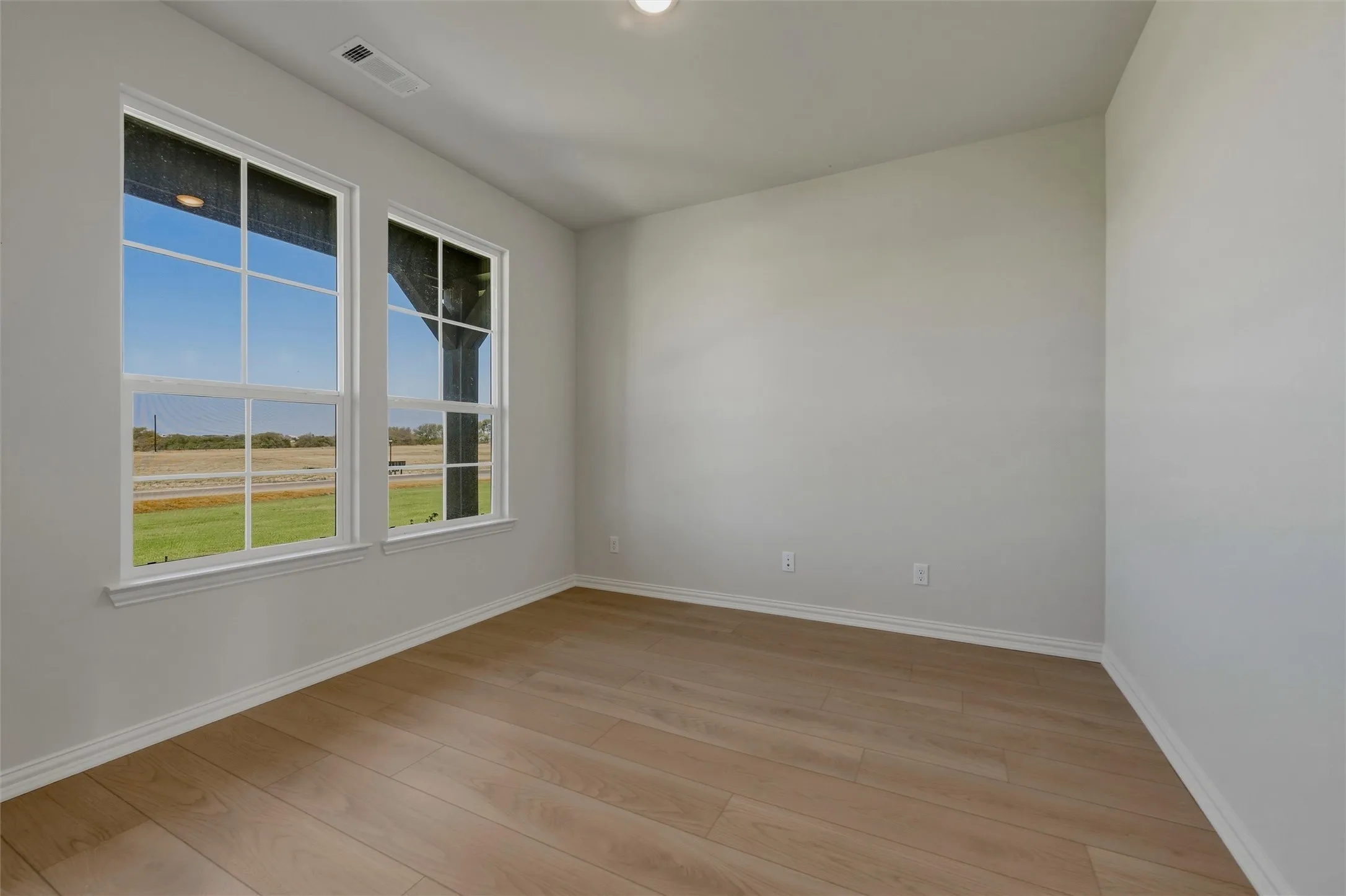 Recessed lighting, wood-finish flooring, white trim, dual pane windows, and light neutral wall tones