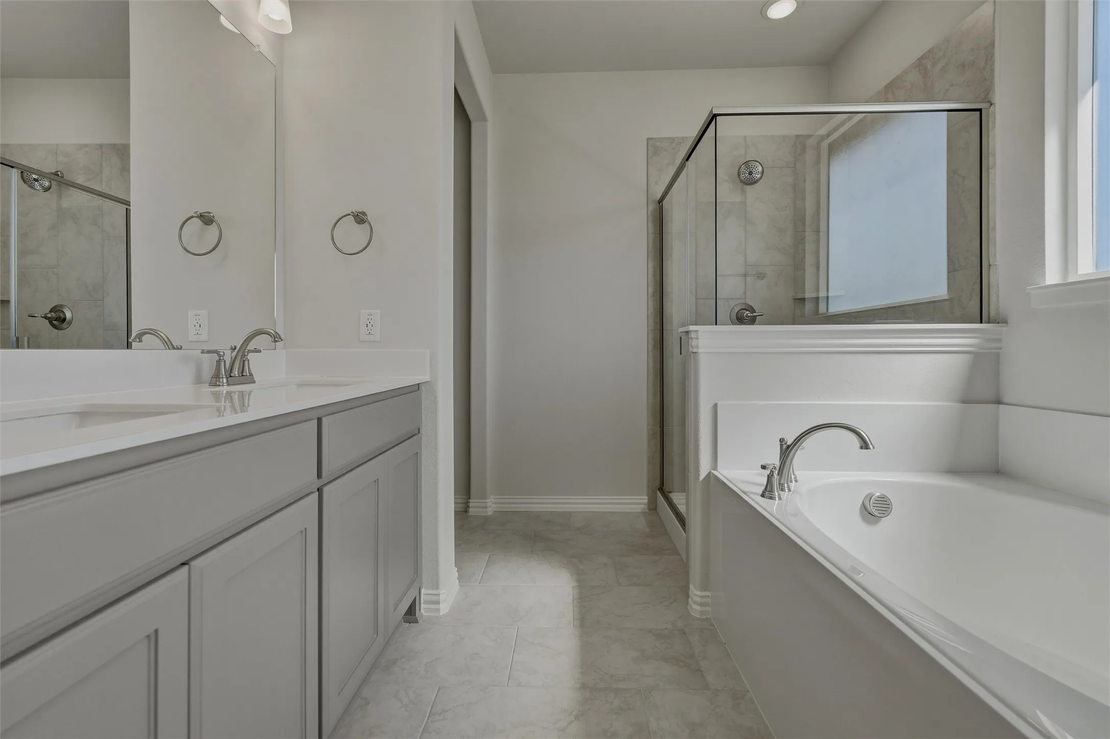 Dual vanity with light gray cabinetry and white countertops