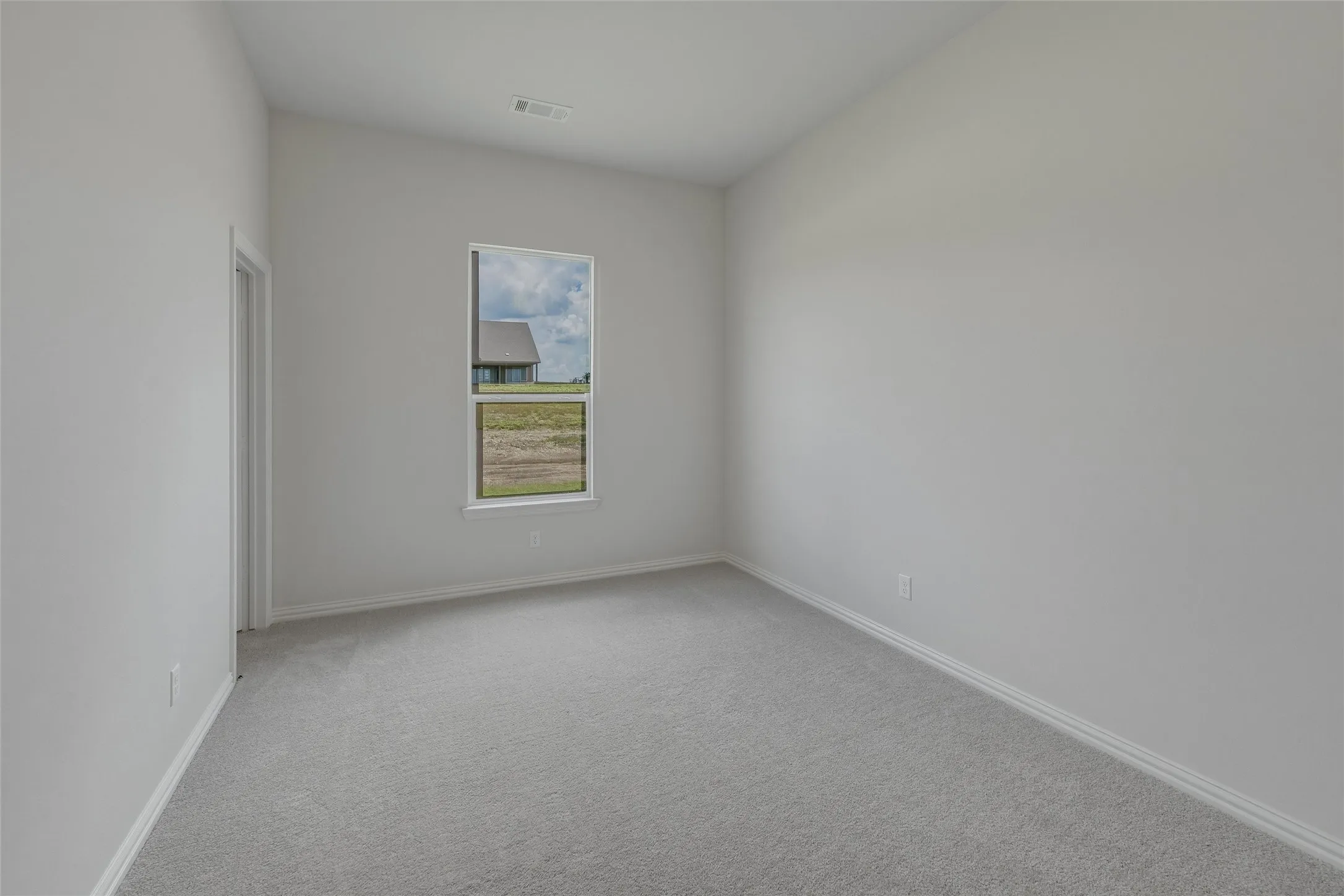 Carpet flooring, neutral wall paint, white trim, and a single window
