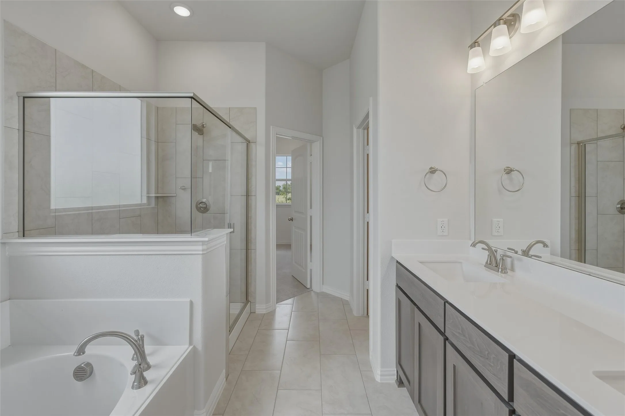 Dual vanity with white countertop, chrome fixtures, and grey wood-finish cabinetry