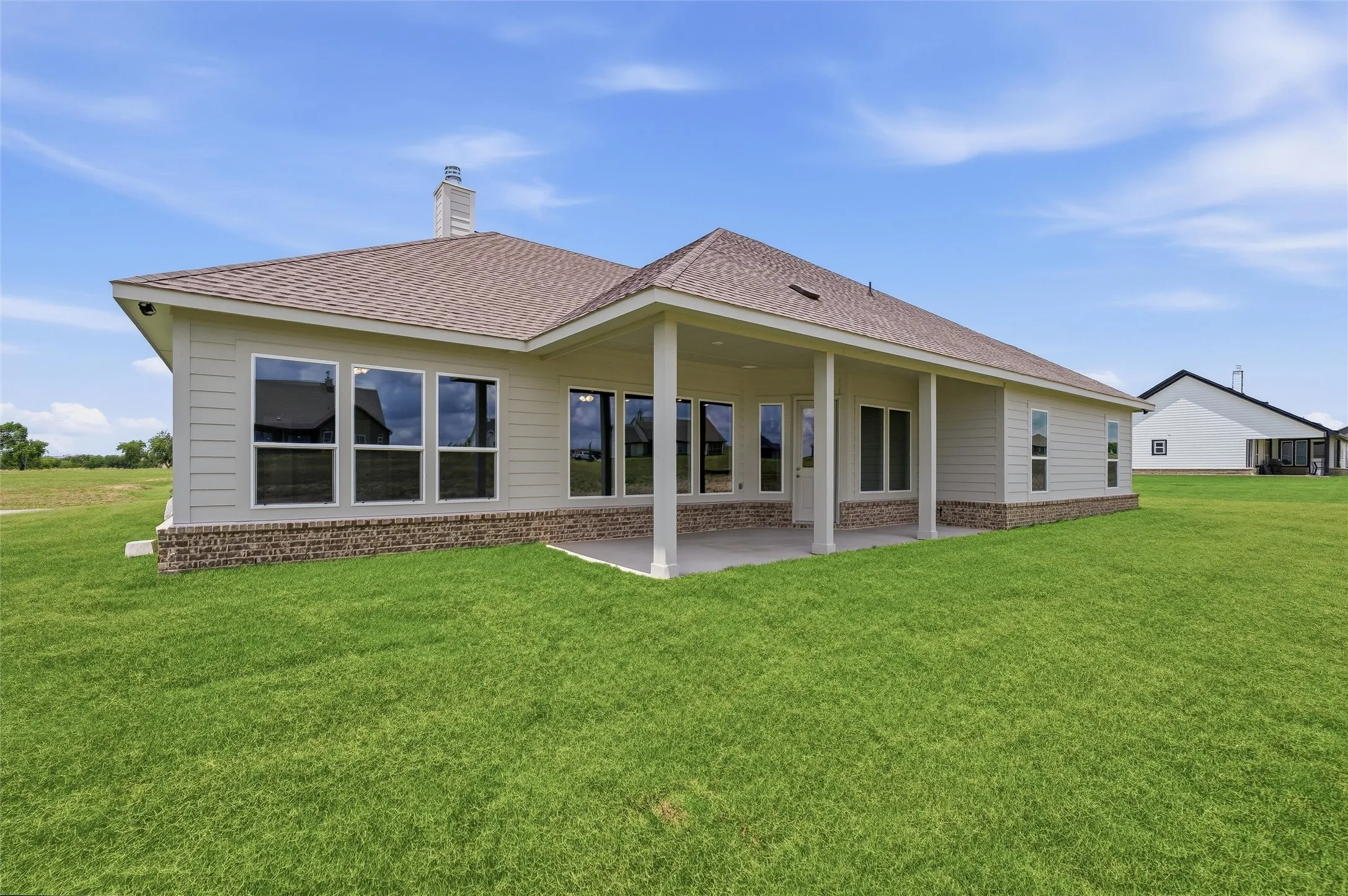 Expansive green lawn surrounds the property