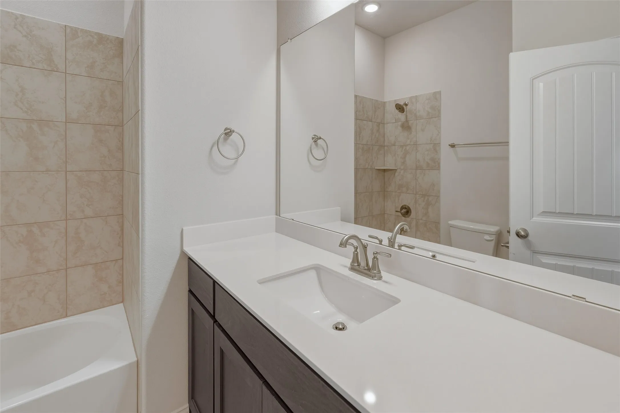 Bathroom vanity with a single basin sink and brushed nickel faucet