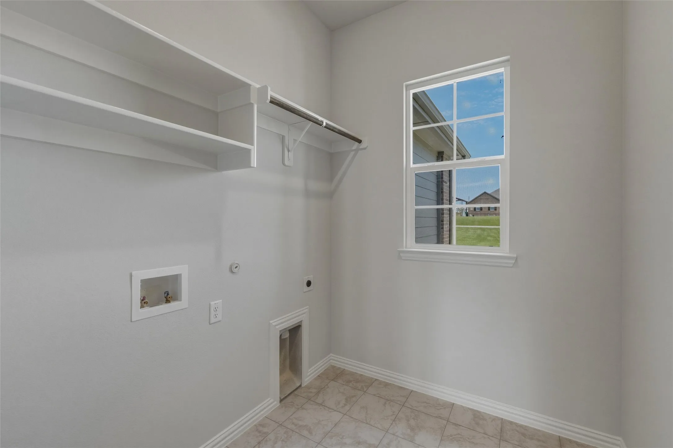 Built-in shelving, hanging rod, and a window with exterior scenery