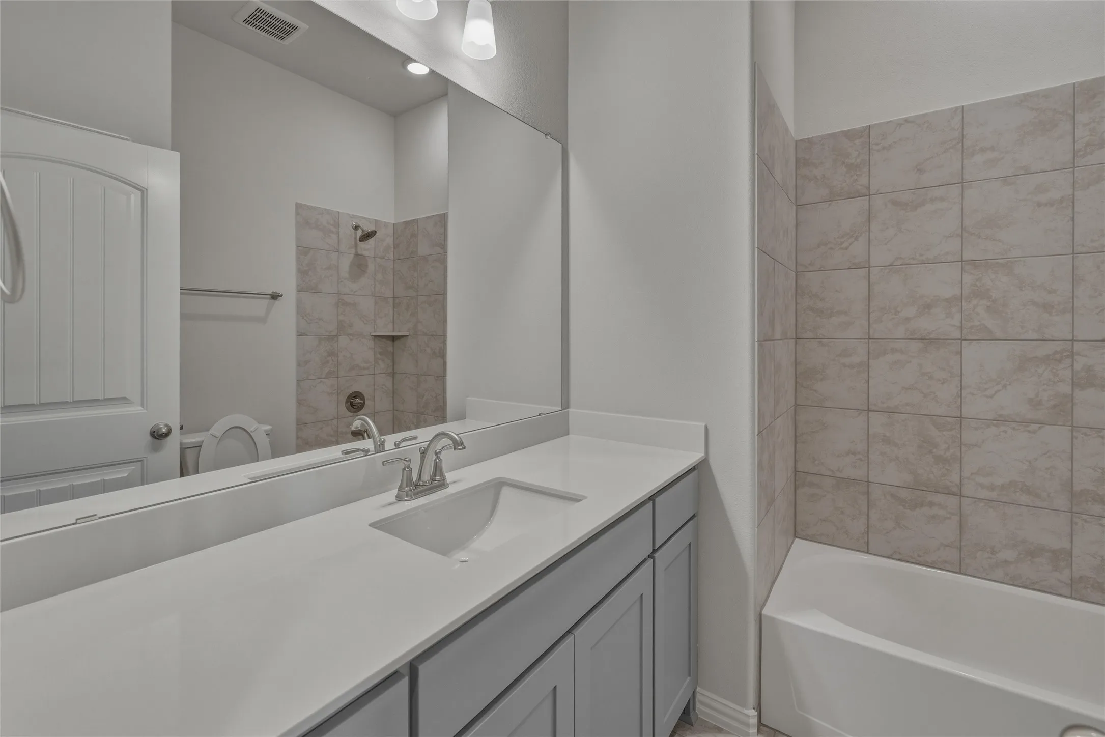 Single vanity with an integrated sink and light grey cabinetry