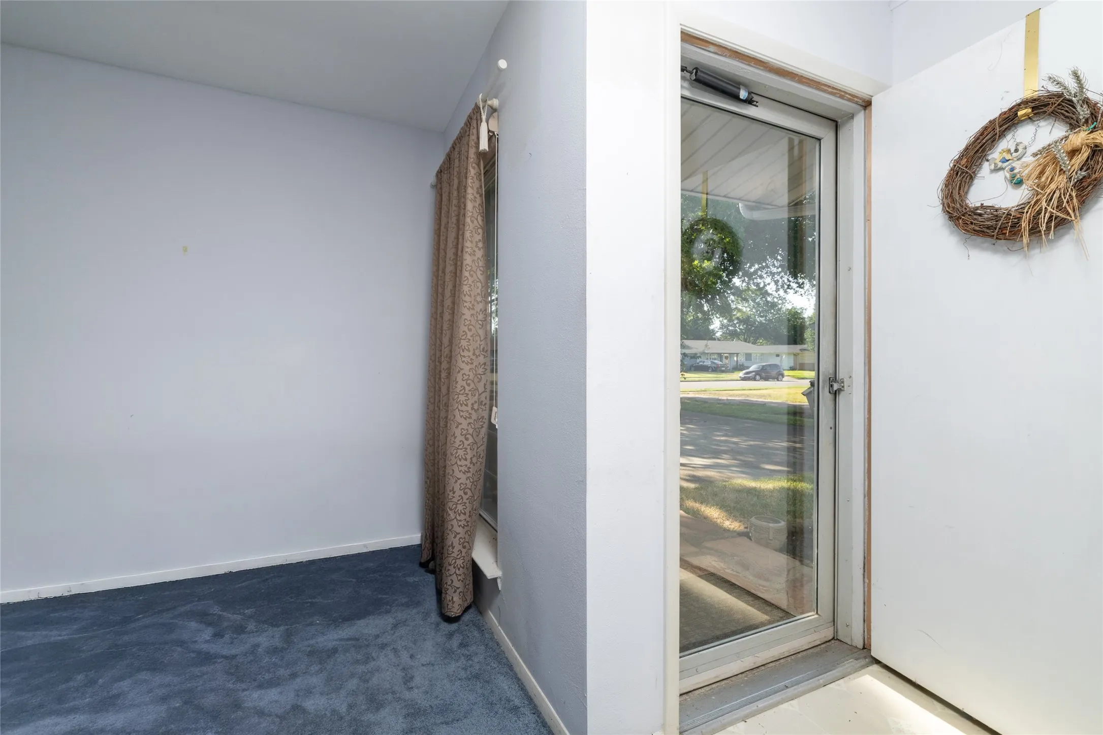 Entryway featuring a full-light storm door and blue carpeting