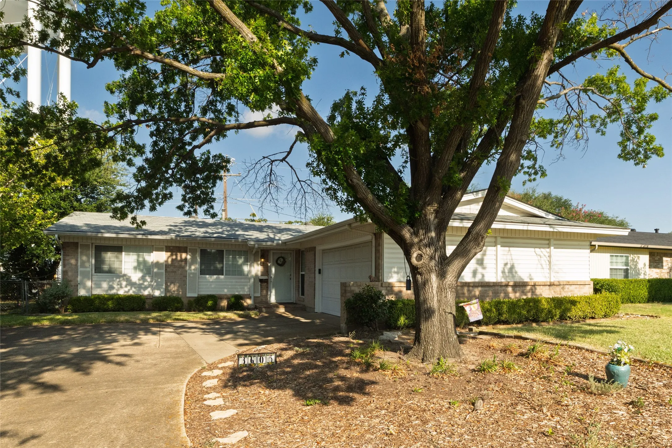Single-story residence featuring a brick and siding exterior, an attached garage, and a concrete driveway