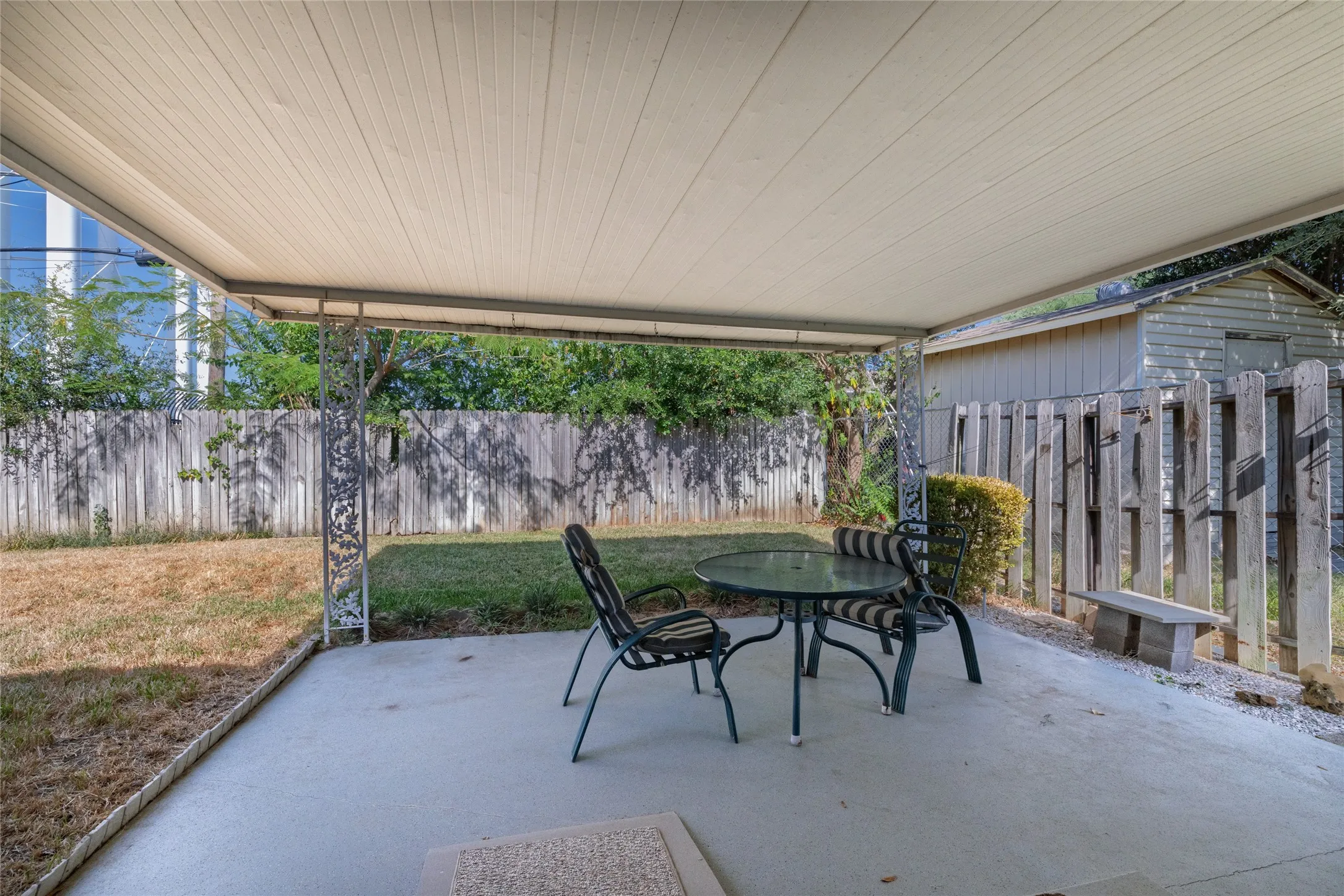 Covered patio featuring a concrete slab and decorative metal supports