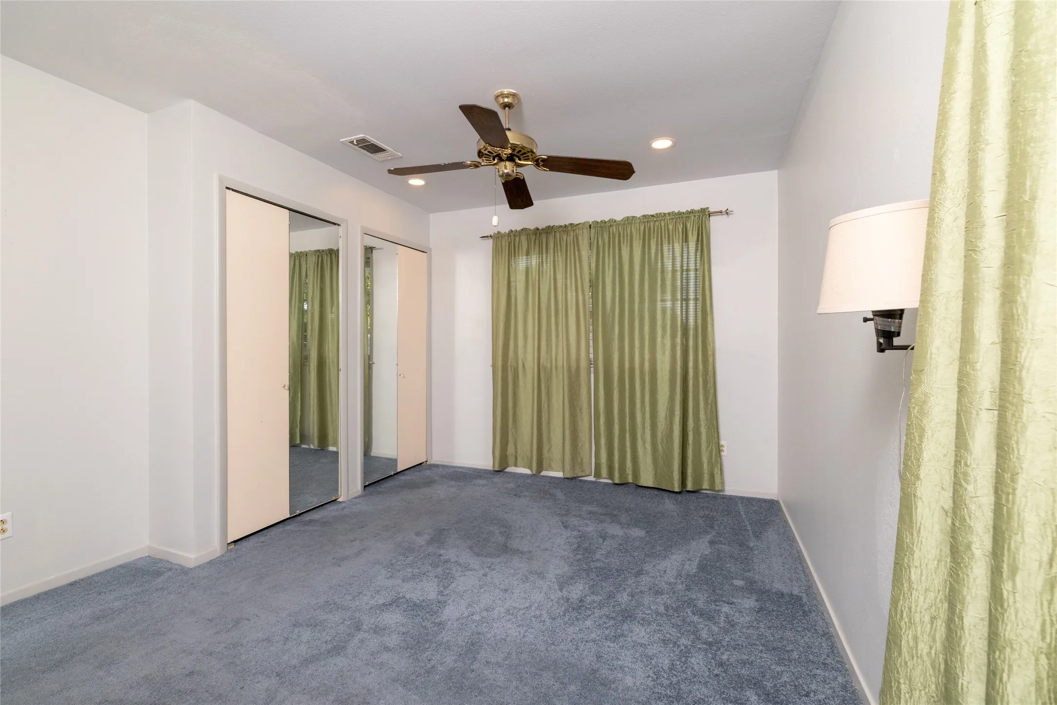 Ceiling fan with light kit, recessed lighting, wall-mounted sconce, and mirrored closet doors