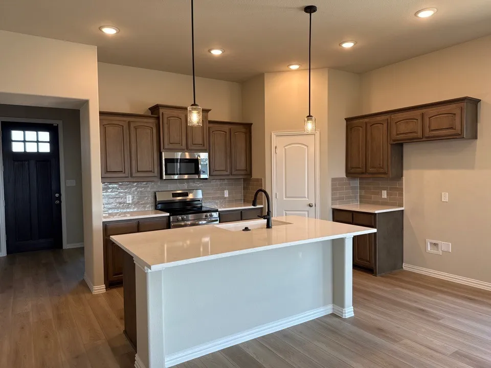 Kitchen featuring a center island with solid surface countertops, dark wood cabinetry, stainless steel appliances, and wood-finish flooring