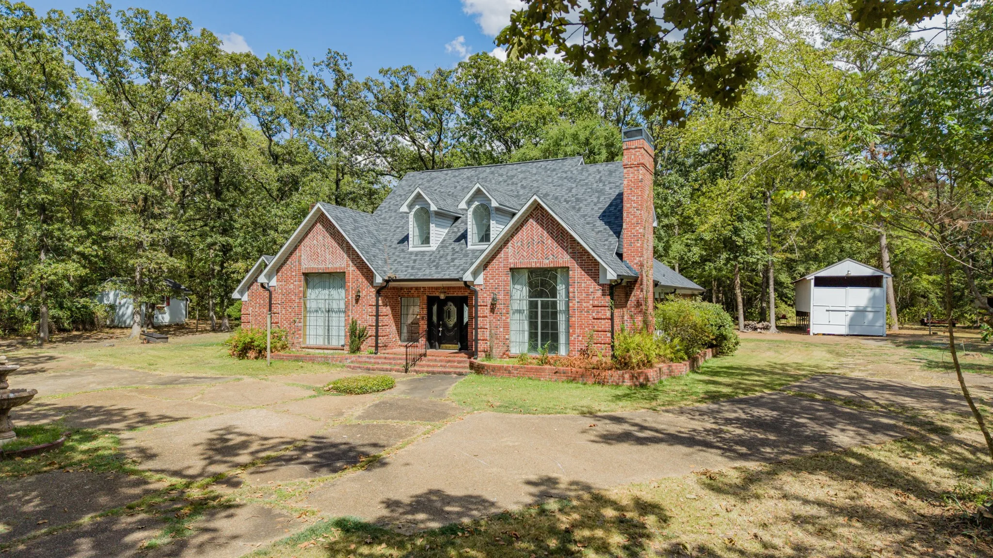 Brick exterior with a dark shingle roof and multiple dormer windows