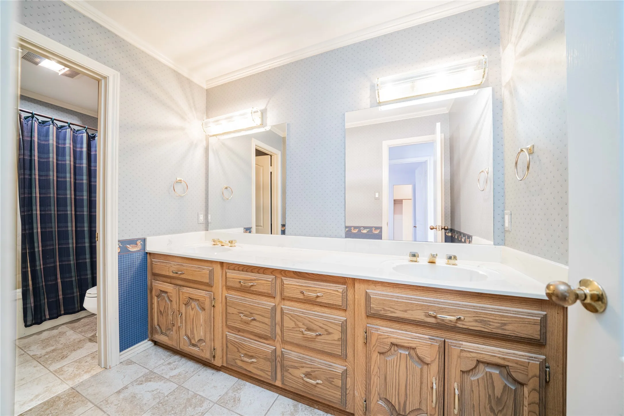 Dual vanity with integrated sinks and brass-toned fixtures