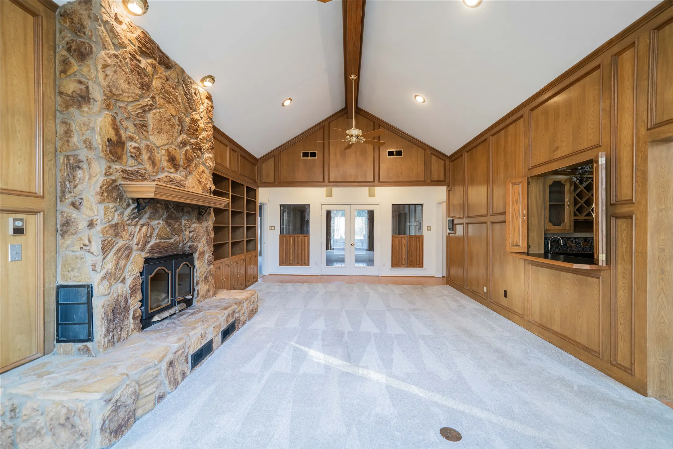 Spacious room featuring a vaulted ceiling and exposed beam